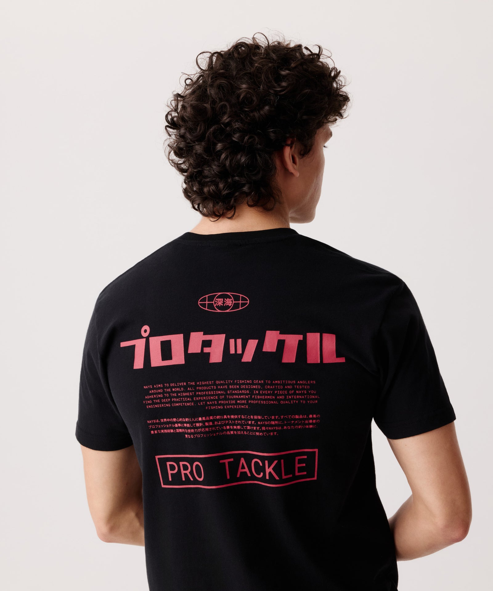 Rückansicht eines Mannes im schwarzen Pro Tackle T-Shirt mit gut sichtbaren Logo-Schriftzügen in Englisch und Japanisch.