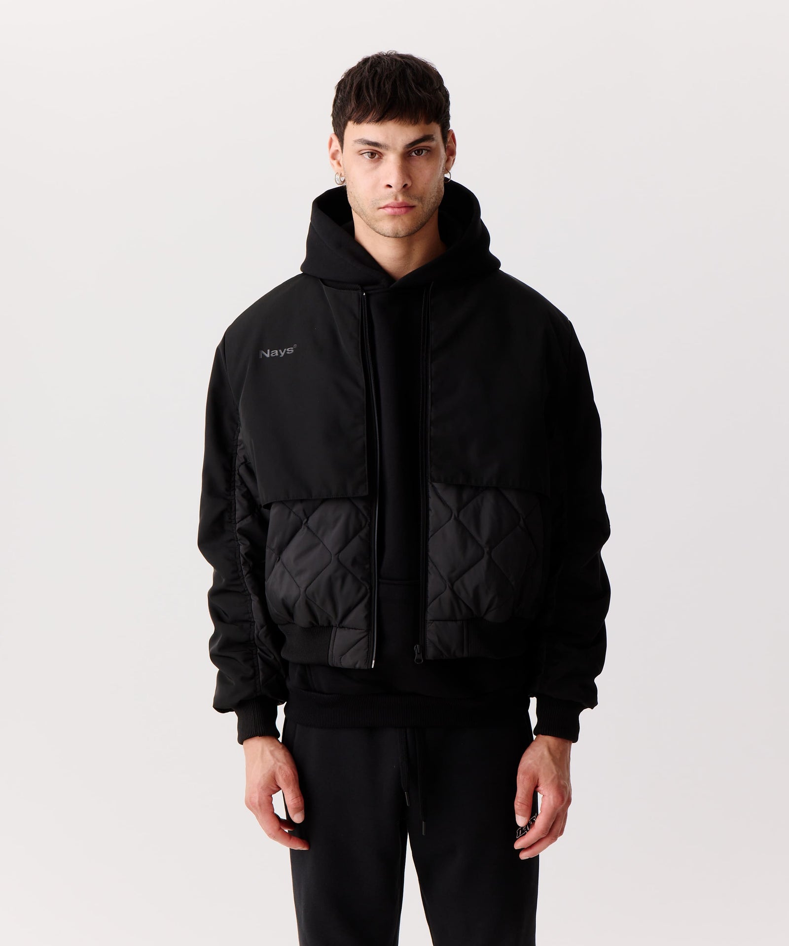 Nays Bomber Jacket mit Stehkragen, verdeckten Brusttaschen und modernem Schnitt, getragen von einem Mann. Perfekt für Outdoor-Aktivitäten dank wasserabweisendem Finish.