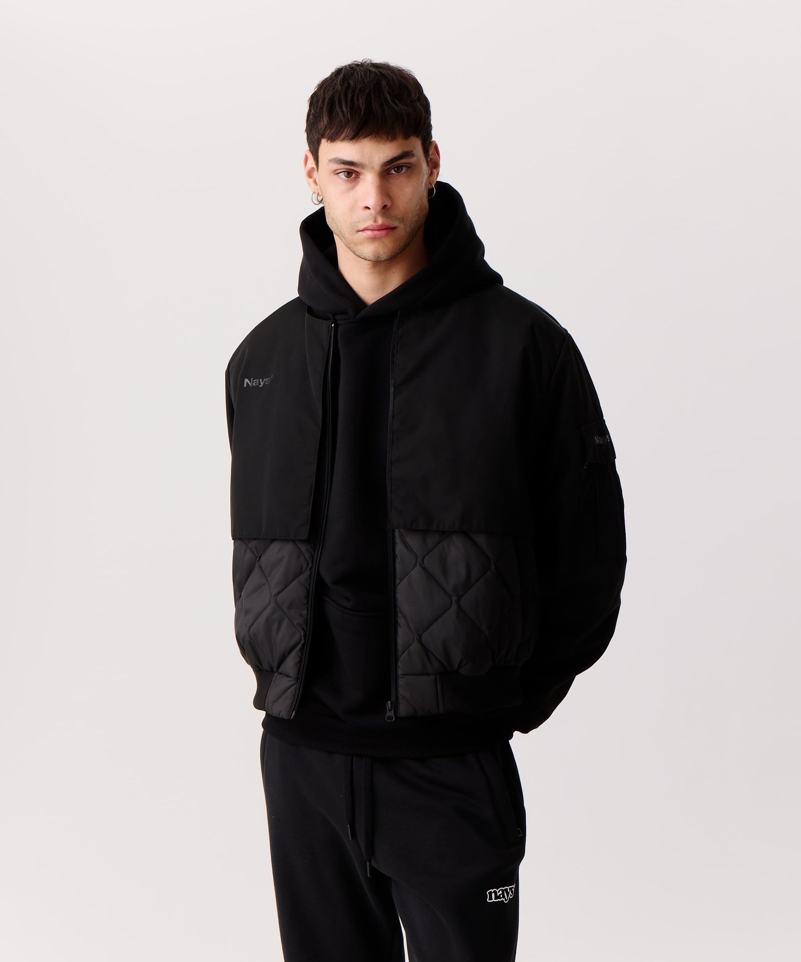 Nays Bomber Jacket mit Stehkragen, verdeckten Brusttaschen und modernem Schnitt, getragen von einem Mann. Perfekt für Outdoor-Aktivitäten dank wasserabweisendem Finish.