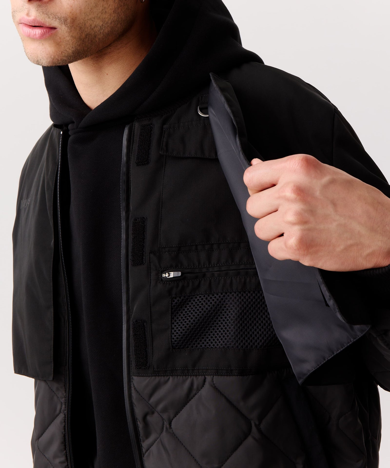 Nays Bomber Jacket mit Stehkragen, verdeckten Brusttaschen und modernem Schnitt, getragen von einem Mann, der die verdeckten Brusttaschen zeigt.