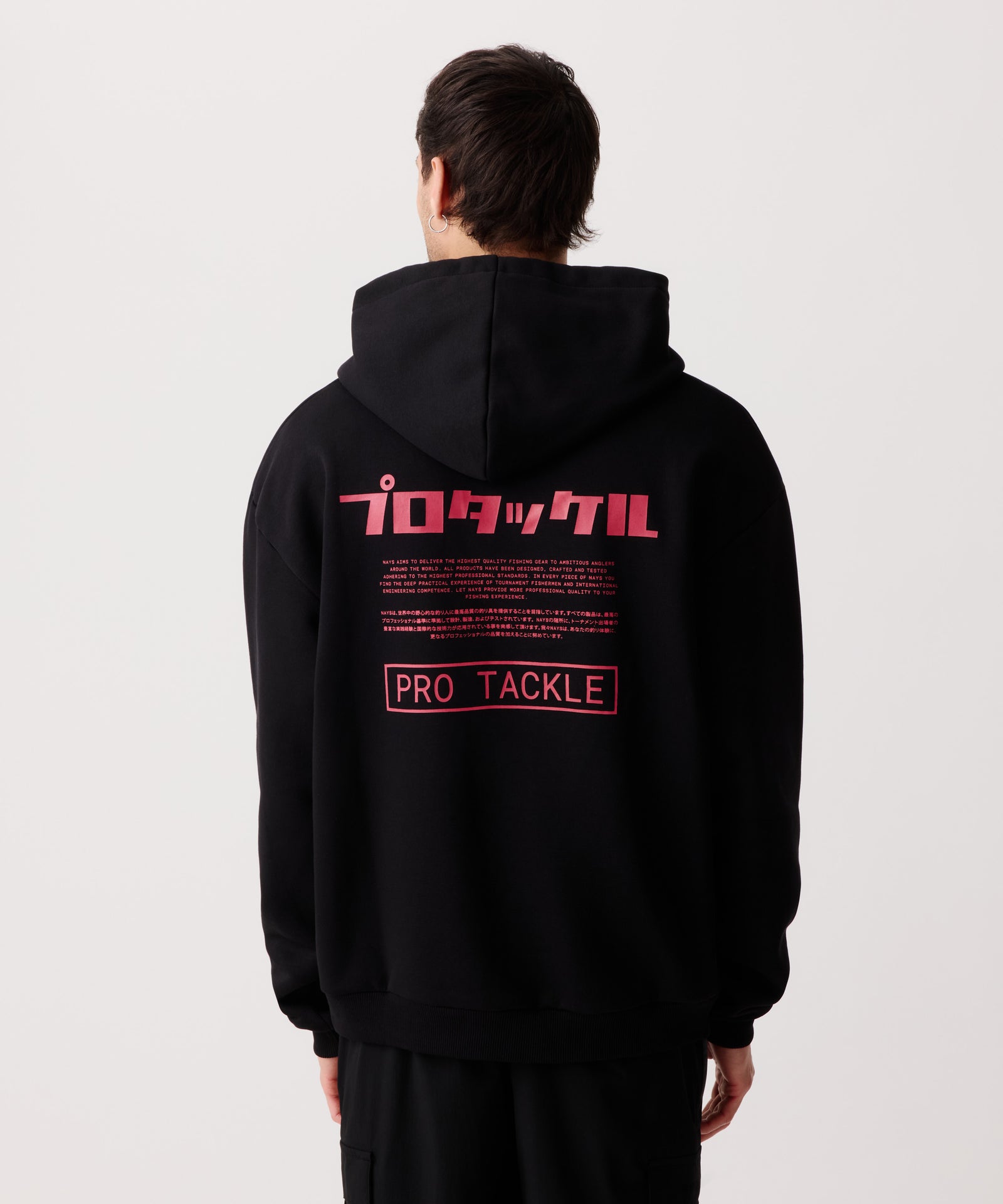 Rückansicht eines Mannes im schwarzen Pro Tackle Kapuzen-Pullover mit gut sichtbaren Logo-Schriftzügen in Englisch und Japanisch.