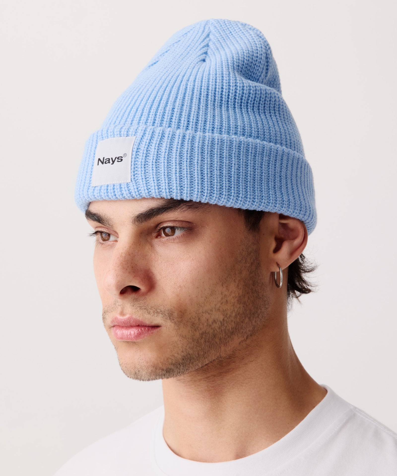 Hell-Blaue Strickmütze mit breitem Umschlag getragen von einem Mann. 
