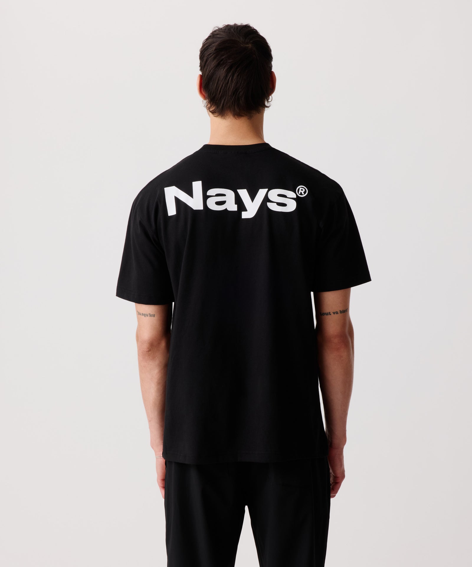 Ein Mann trägt unser schwarzes Logo T-Shirt mit Rücken-Print in der Rück-Ansicht.
Deutlich zu erkennen das auffällige, weiße Logo auf den Schultern.