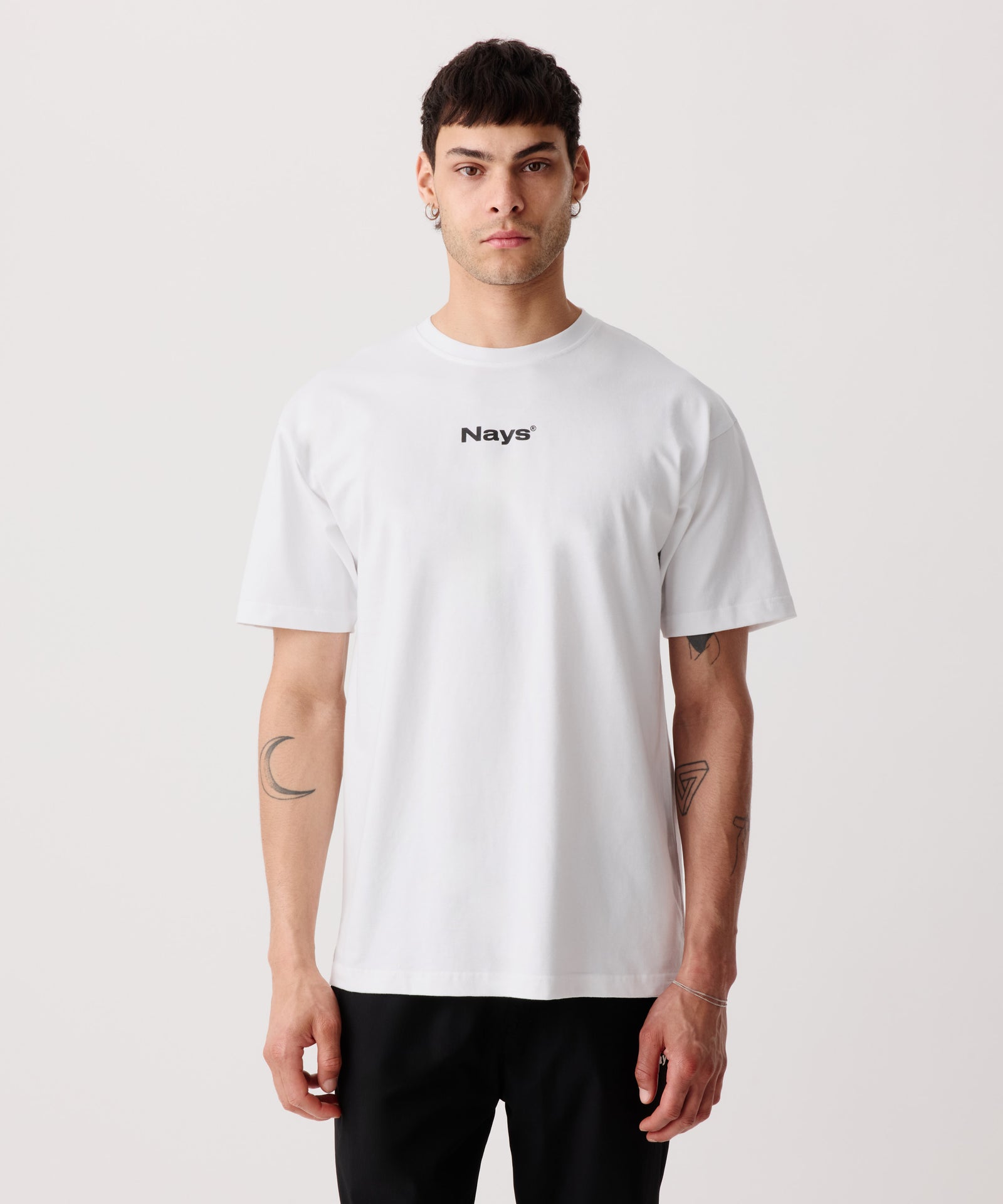 Das Bild zeigt das weiße Basic T-Shirt mit Front-Print getragen von einem Mann. 