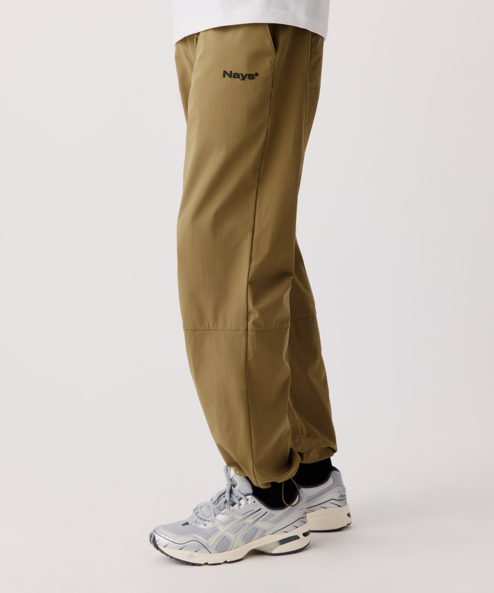 Das Produktbild zeigt die Nays Summer Pants getragen von einem Mann im Seitenprofil. Er trägt ein weißen T-Shirt und helle Turnschuhe.