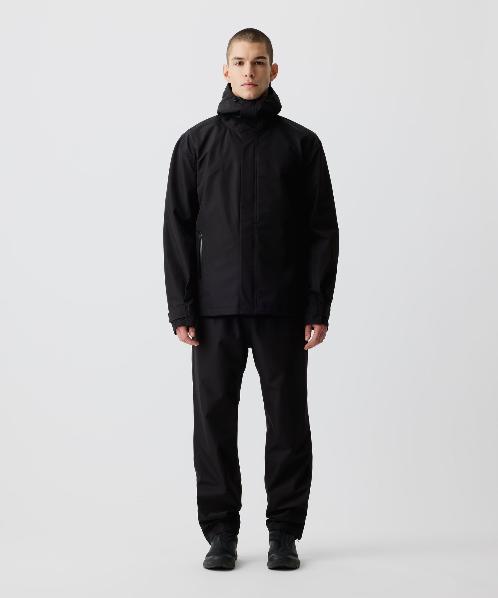 Ein Mann trägt die Nays 3L Multifunctional Rain Jacket in der Frontalansicht, ideal für Outdoor-Abenteuer, mit verstellbarer Kapuze und wasserdichten Reißverschlüssen.