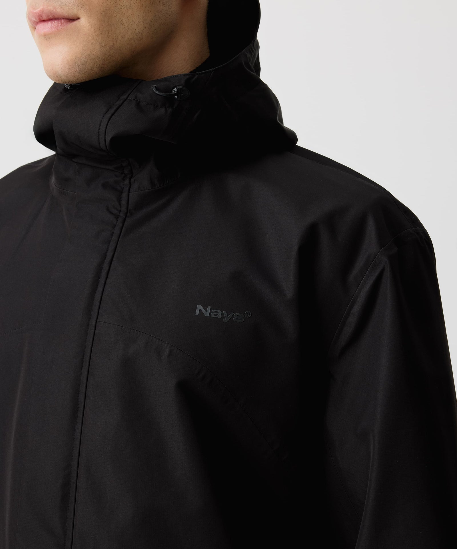 Ein Mann trägt die Nays 3L Multifunctional Rain Jacket mit verstellbarer Kapuze, YKK AquaGuard® Reißverschlüssen und Belüftungsreißverschlüssen für optimalen Wetterschutz.