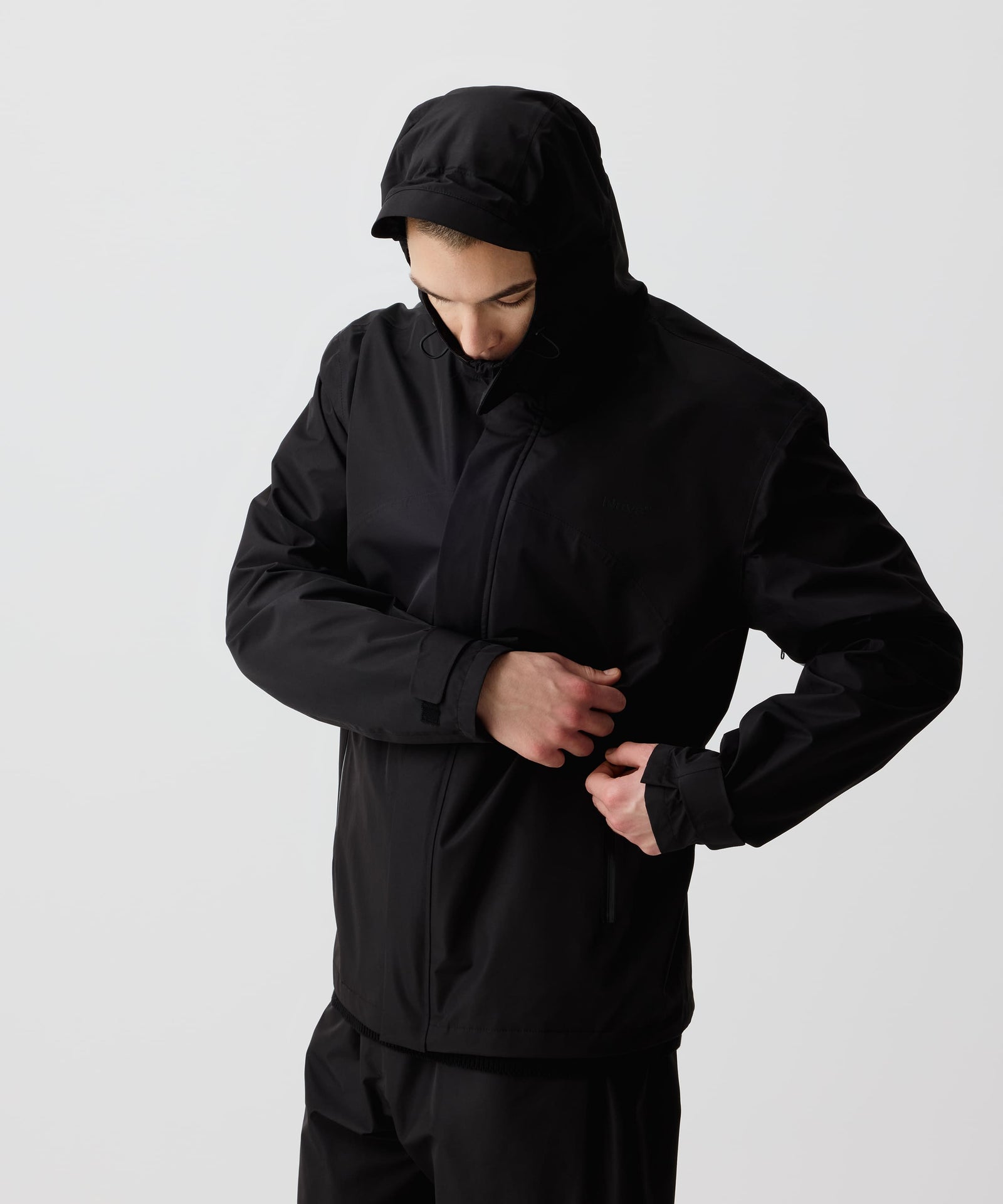 Mann trägt die Nays 3L Multifunctional Rain Jacket mit verstellbarer Kapuze und wasserdichten Reißverschlüssen. Ideal für Regen und Outdoor-Aktivitäten.