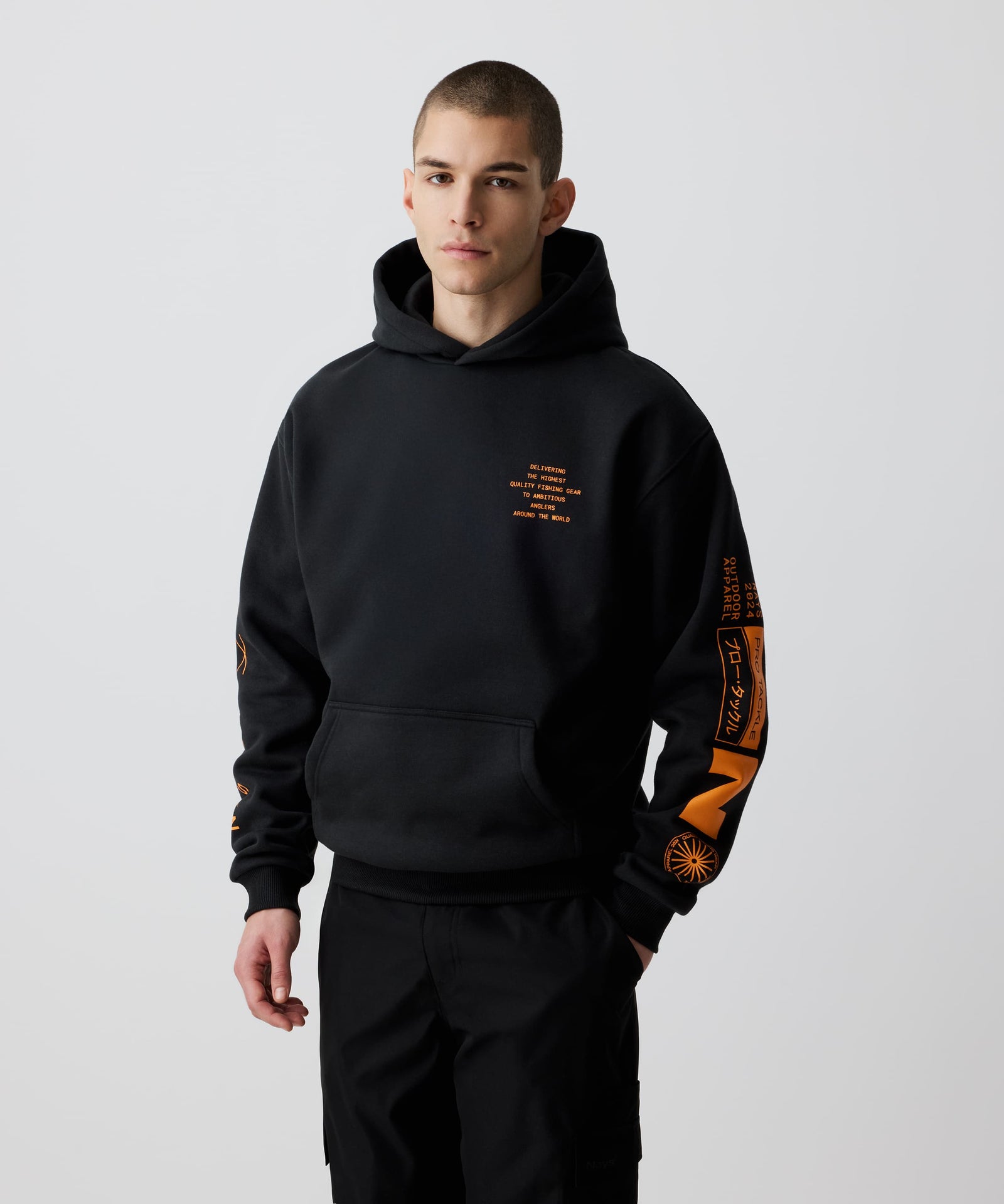Ein Mann trägt den Nays Quote Hoodie mit auffälligem orangefarbenem Grafik-Print, ideal für den Alltag durch komfortable Fleece-Innenseite und lässigen Schnitt.