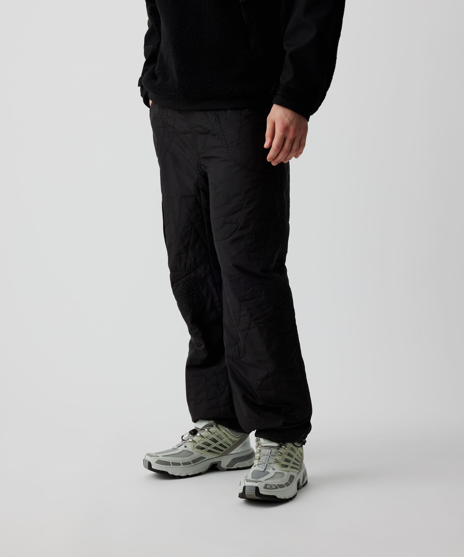 Person trägt Nays Thermo Hose mit elastischem Bund und verstellbarem Saum, ideal für Kälteschutz. Weiße Schuhe ergänzen den Look.