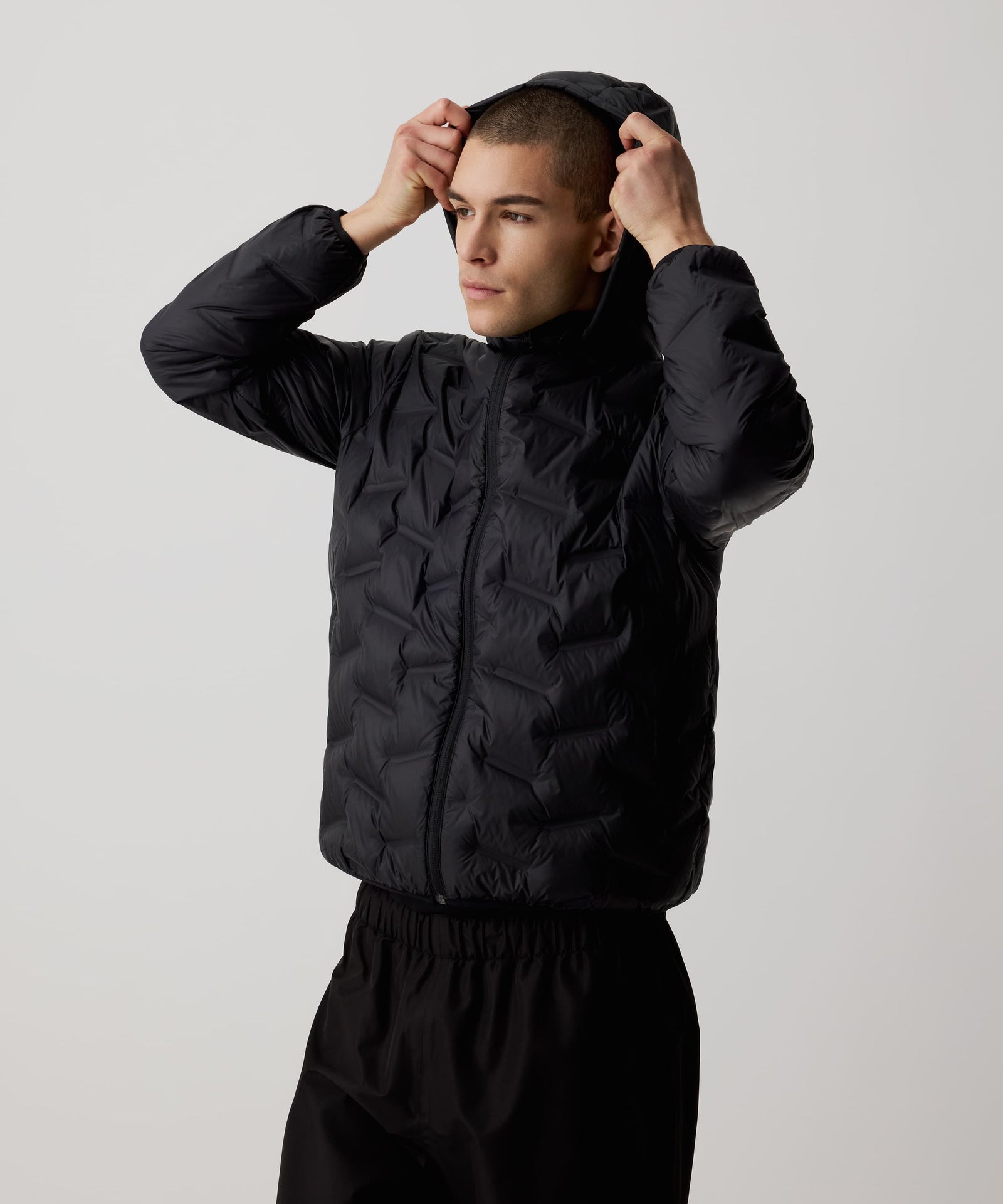 Ein Mann trägt die Nays Lightweight Down Jacket mit Kapuze, Reißverschlüssen und Seitentaschen, ideal für kalte Tage und Outdoor-Abenteuer.