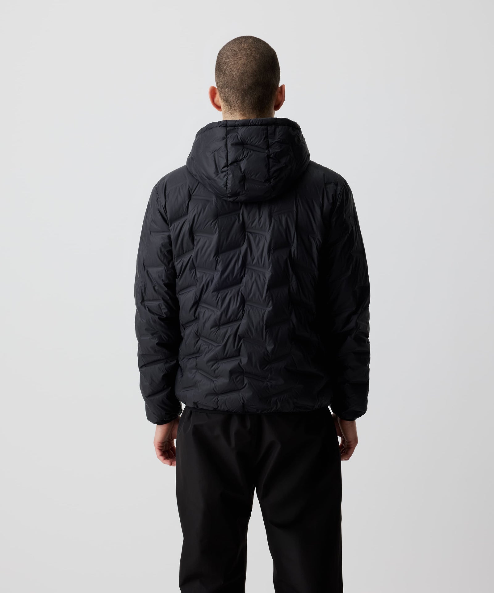 Ein Mann trägt die Nays Lightweight Down Jacket mit Kapuze in der Rückansicht. Ideal für kalte Tage und Outdoor-Abenteuer.