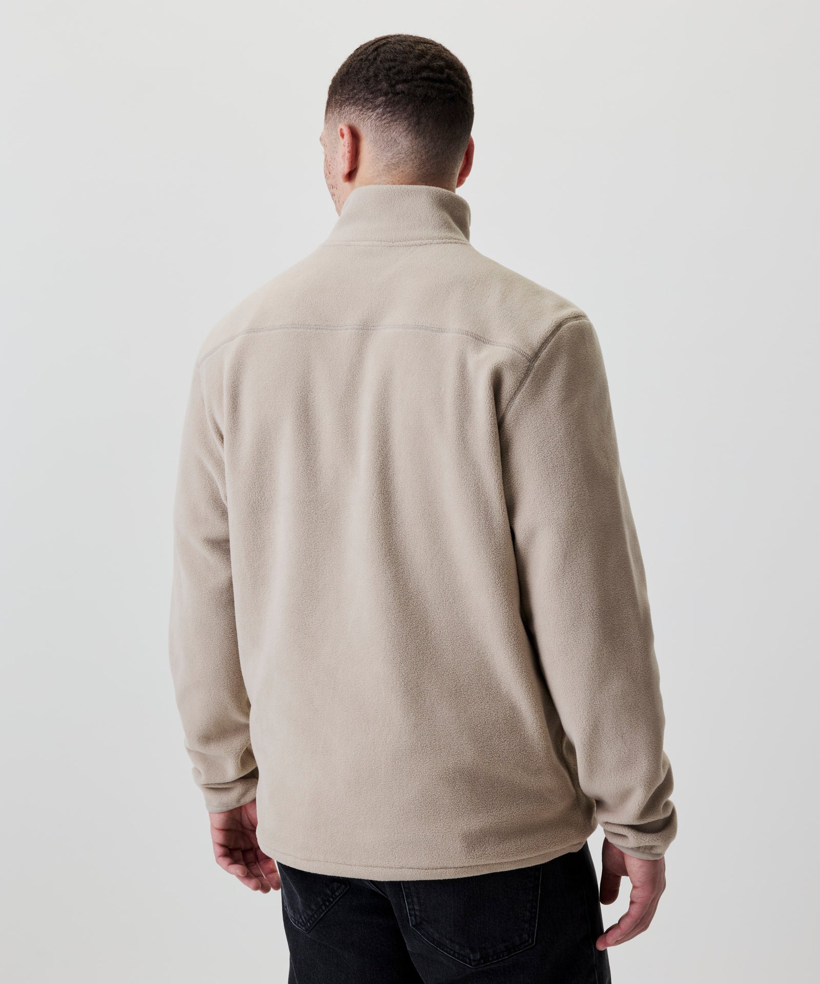 Rückansicht beiger Fleece-Pullover mit Stehkragen.