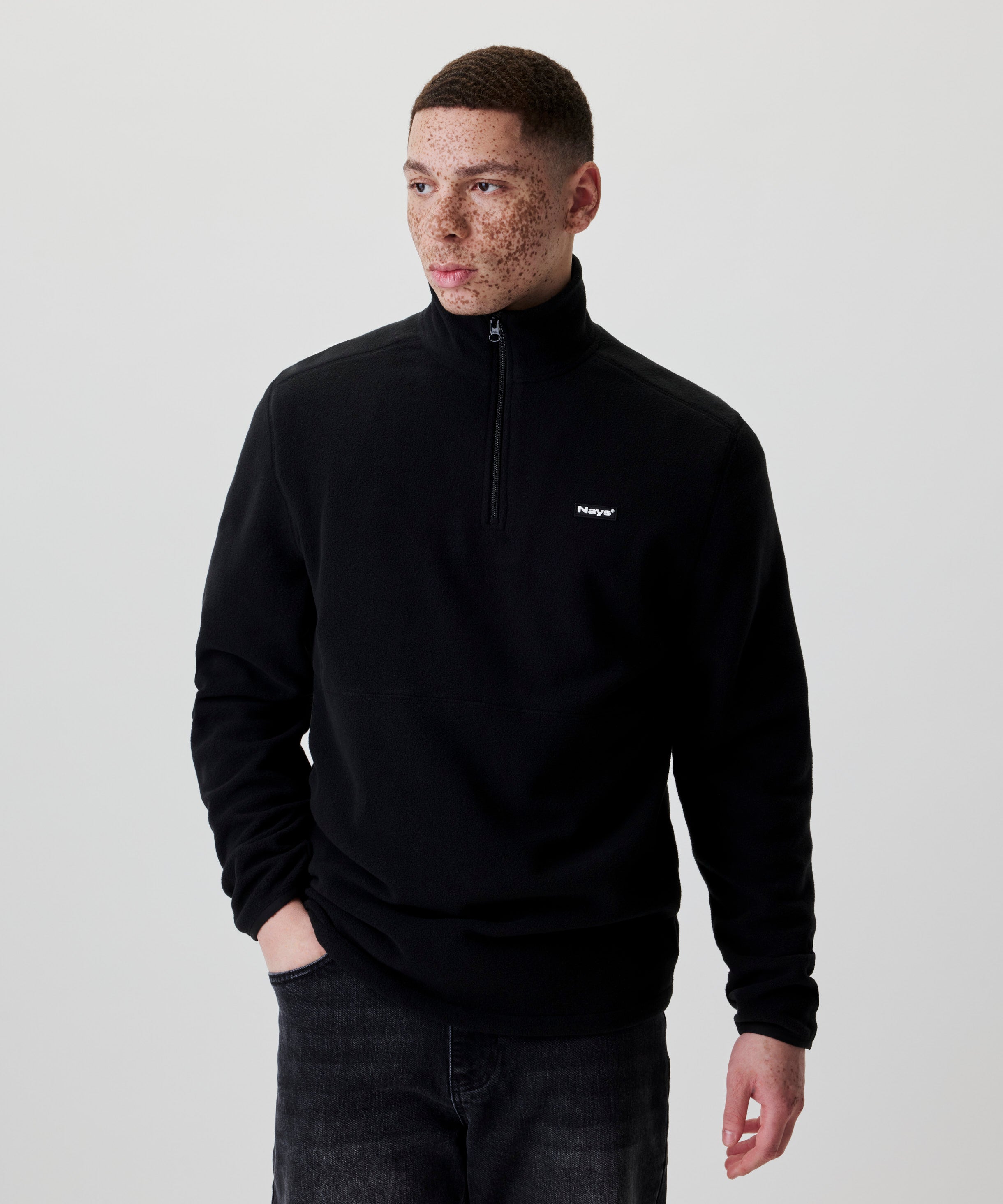 Nays Fleece Halfzip in Schwarz, Herrenmodell trägt den Fleecepullover mit einer Hand in der Tasche.
