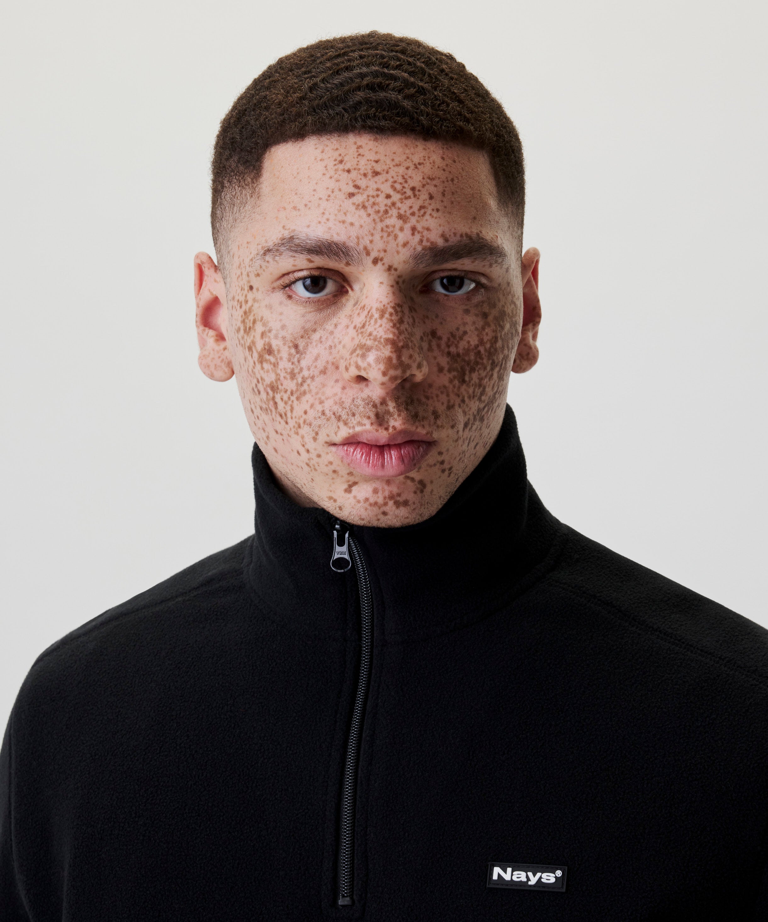 Detailansicht Nays Fleece Halfzip Black mit Fokus auf Kragen, Reißverschluss und Marken-Logo auf der Brust.