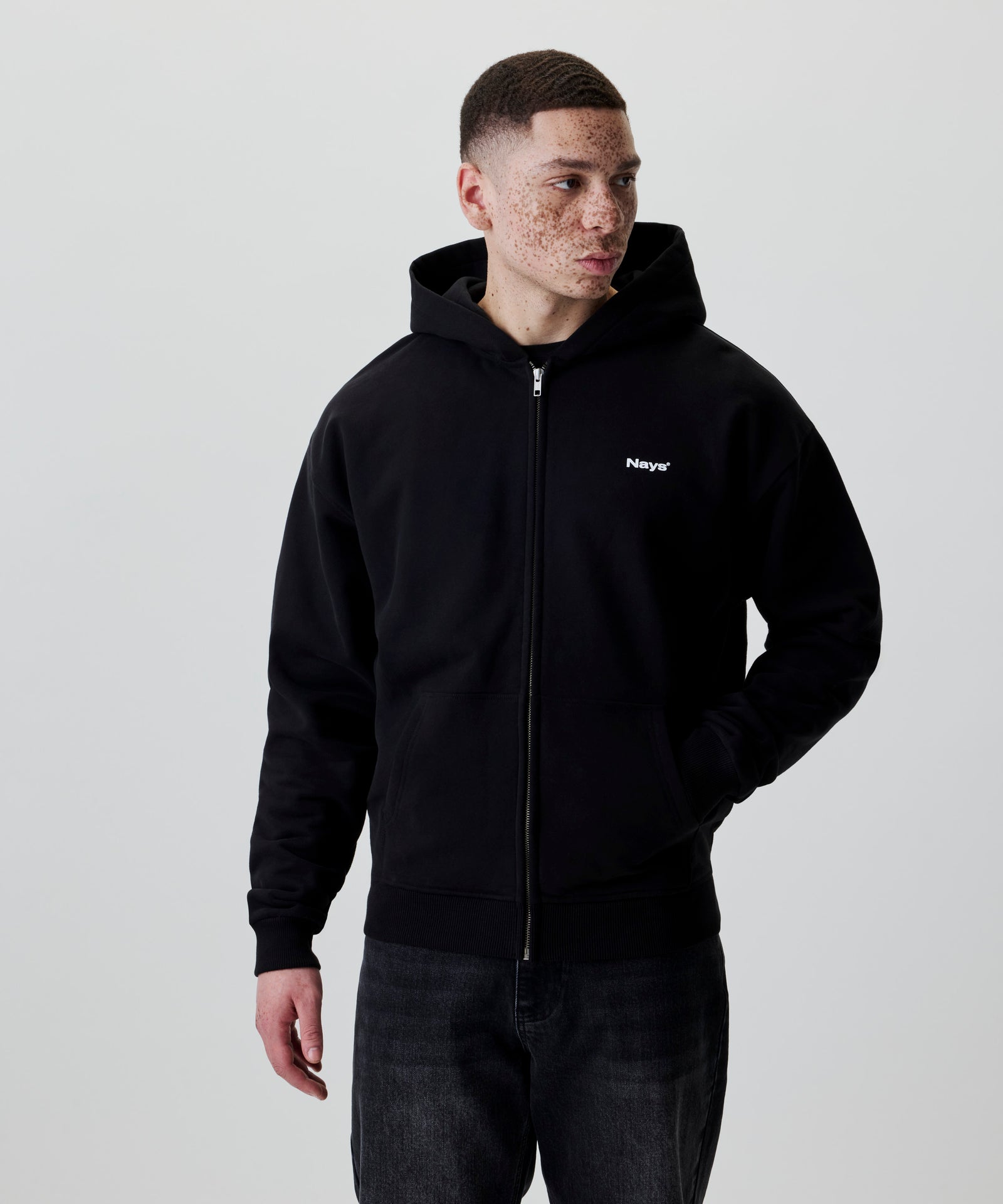 Schwarze Kapuzenjacke mit Nays Logo und Reißverschluss, Seitenansicht.