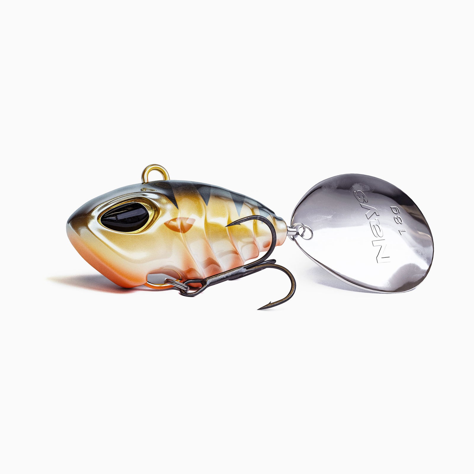 Das Bild zeigt einen Jig Spinner. Der tropfen-förmige Körper ist farblich abgestuft von Schwarz über Gold Orange mit roten Akzenten. Realistisches Augen-Design, ausgestattet mit einem BKK Drillingshaken und einem silbernen Spinner Blatt. 