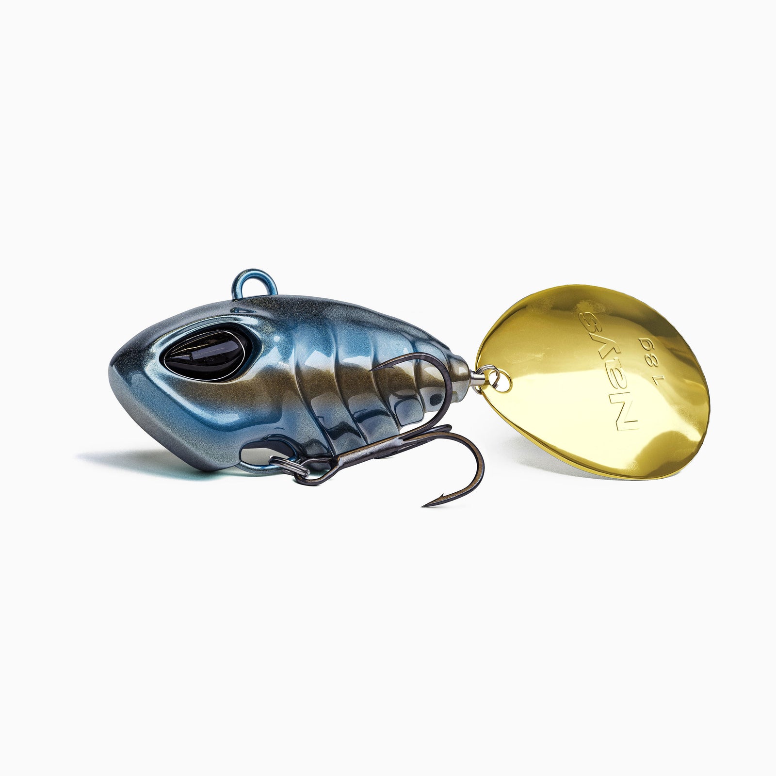 Das Bild zeigt einen Jig Spinner. Der tropfen-förmige Körper ist metallic Blau mit einem schwarzen Akzent auf der Bauchseite. Realistisches Augen-Design, ausgestattet mit einem BKK Drillingshaken und einem goldenen Spinner Blatt. 