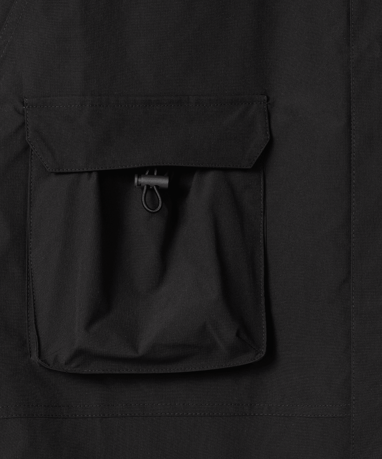 Nays Utility Shirt, eine leichte Shirt-Jacke mit Reverskragen, aufgesetzten Taschen, wasserabweisendem Finish und elastischen Drawstrings. Fokus liegt auf einer der beiden Bauchtaschen.