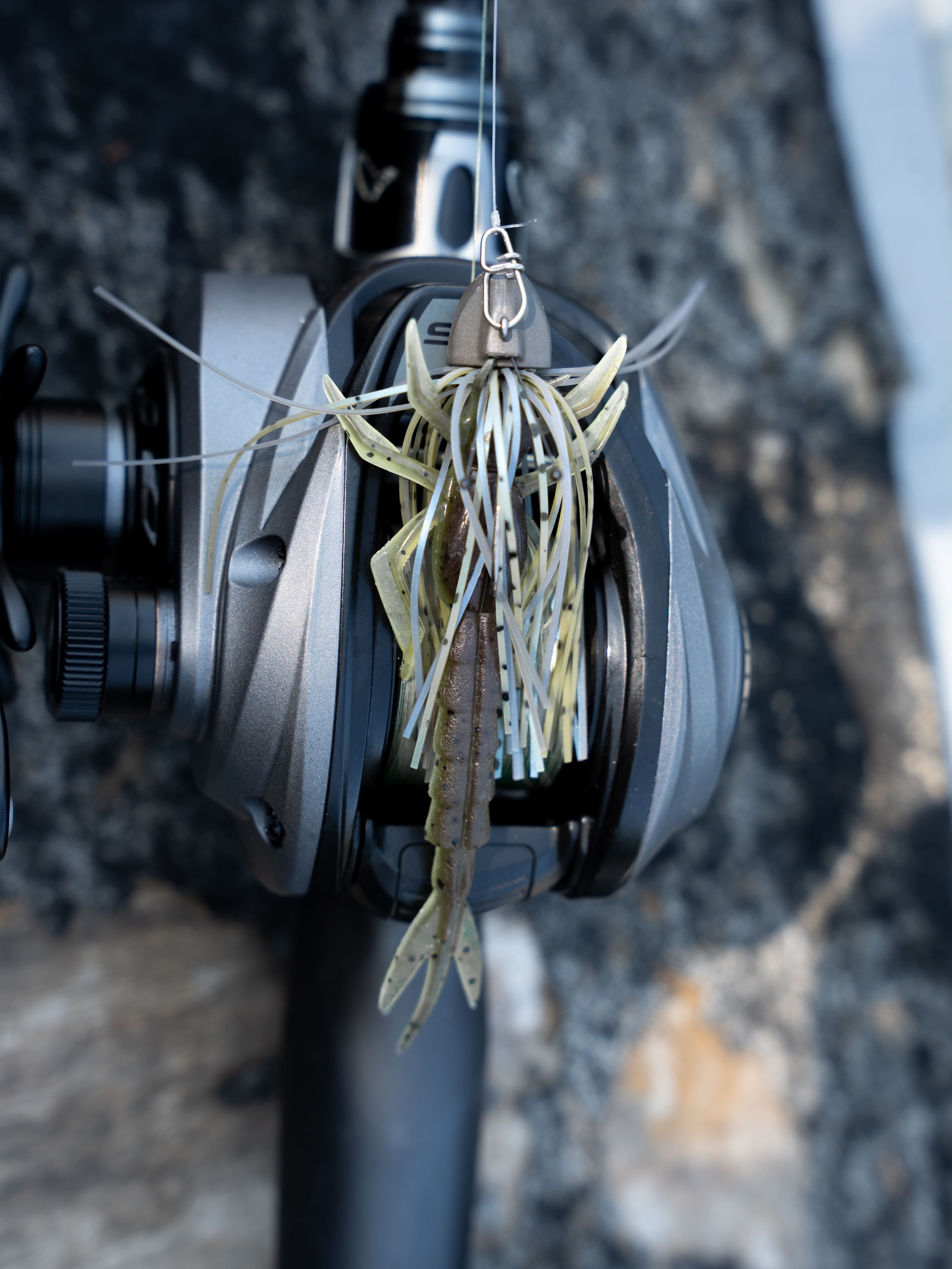 Angelköder mit Gummikrebs-Trailer montiert an einer Baitcaster-Angelrolle zum Spinnfischen auf Raubfische.