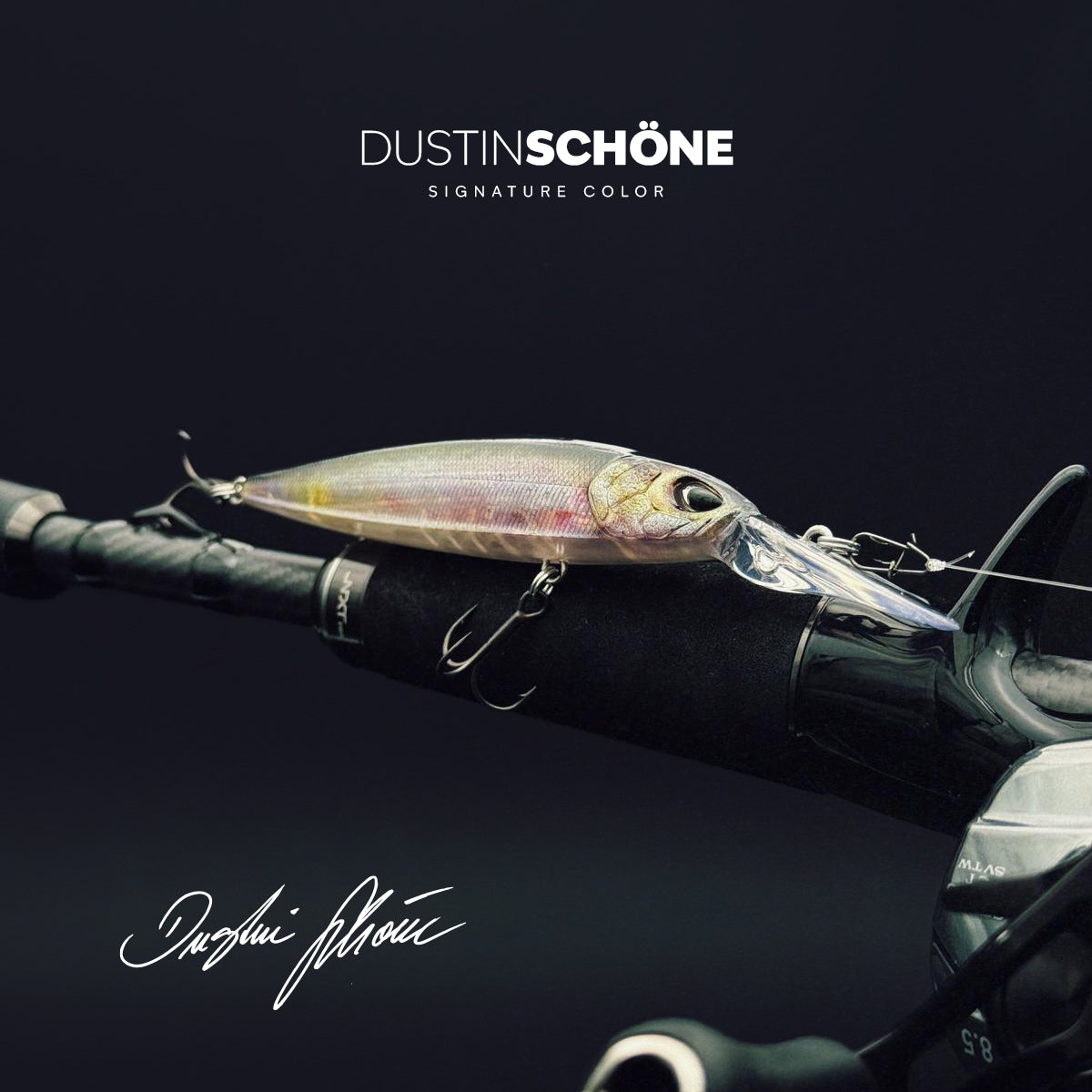 Ein schlanker, silber-transparenter Angelköder mit Dustin Schöne Signature Logo. Der Köder liegt auf dem Griff einer Baitcaster-Rute und zeigt realistische Schuppendetails und eine lange Tauchschaufel.