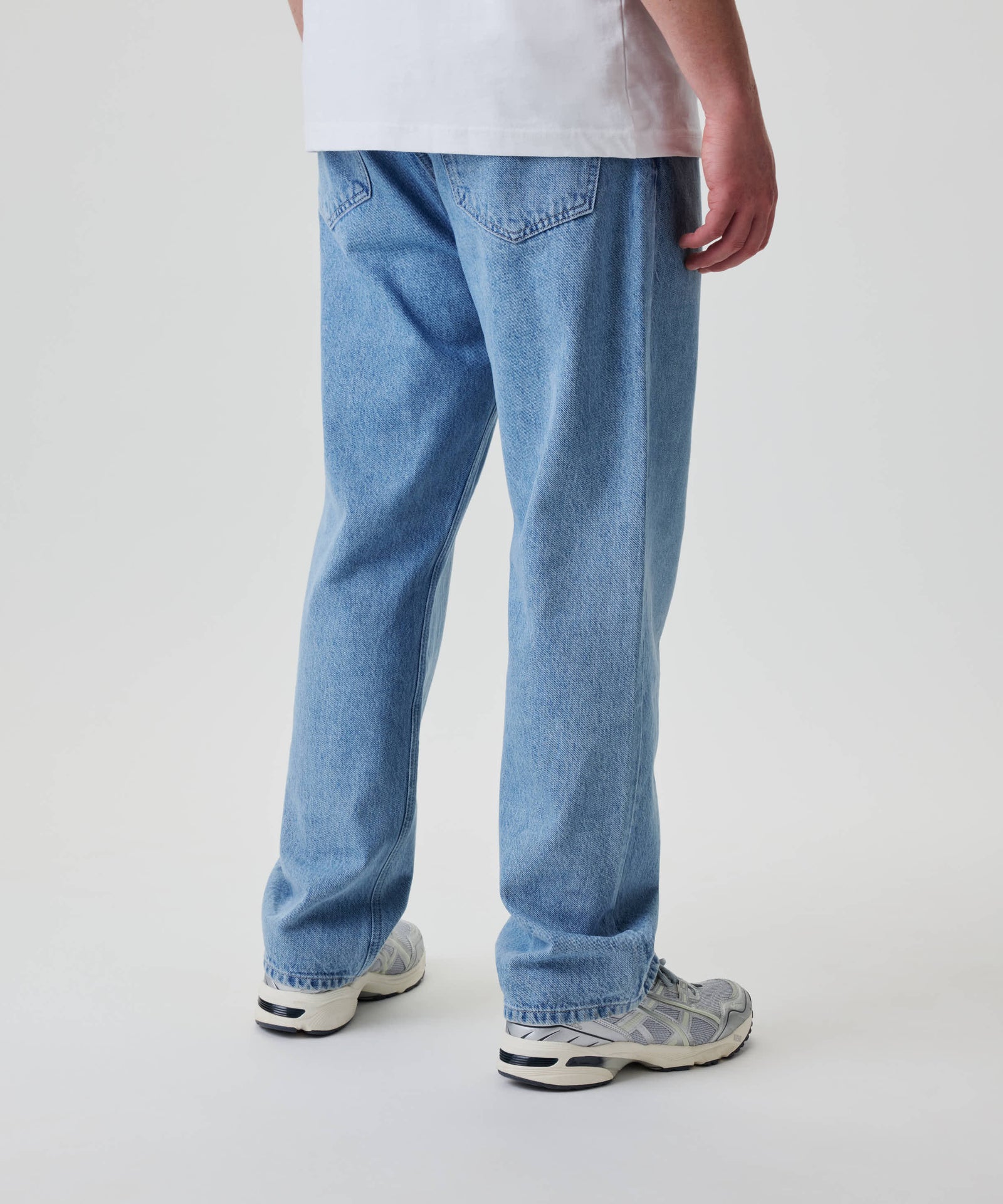 Nays Straight Fit Jeans in hellem Wash, locker geschnitten, mit klassischem 5-Pocket-Design, getragen mit grauen und weißen Sneakers, sichtbar von hinten.