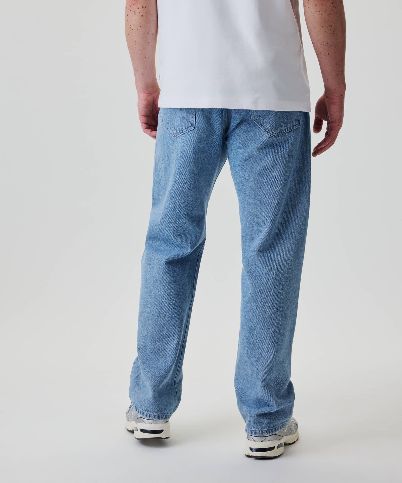 Nays Straight Fit Jeans in hellem Wash, aus 100% Baumwolle, mit klassischem 5-Pocket-Design und geradem, lockerem Schnitt, getragen mit weißen Sneakers.