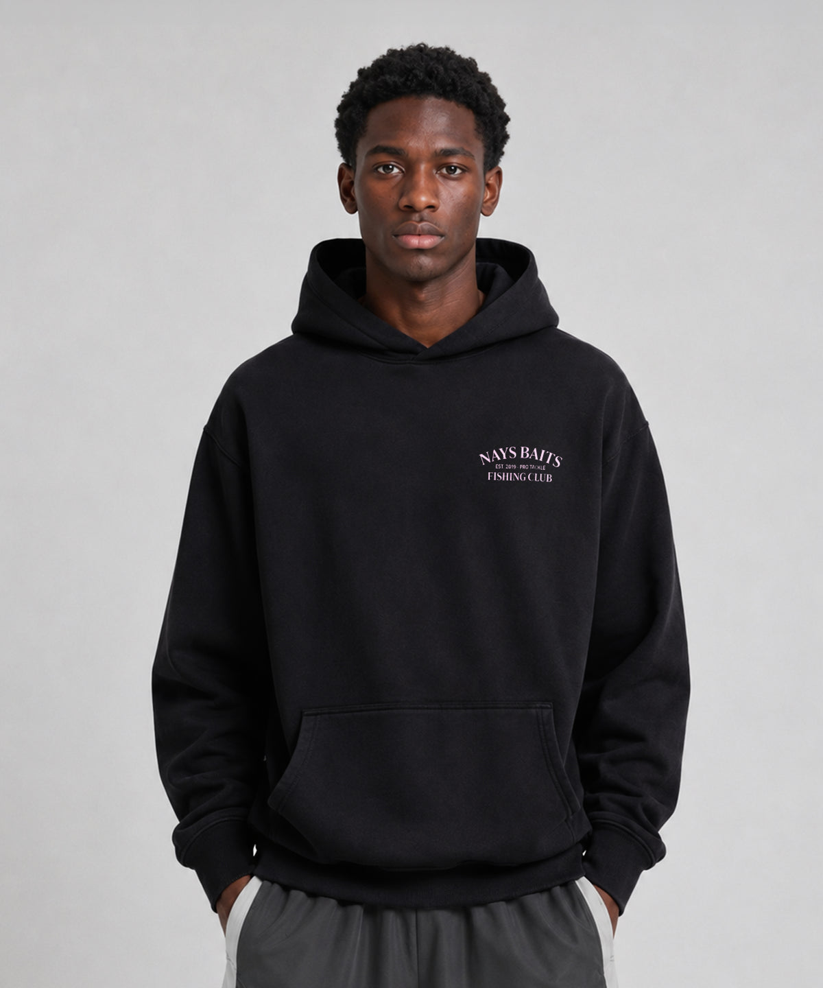 Model trägt Schwarzer Nays Baits Fishing Club Hoodie mit Kapuze, Kängurutasche und dezentem Brustprint.