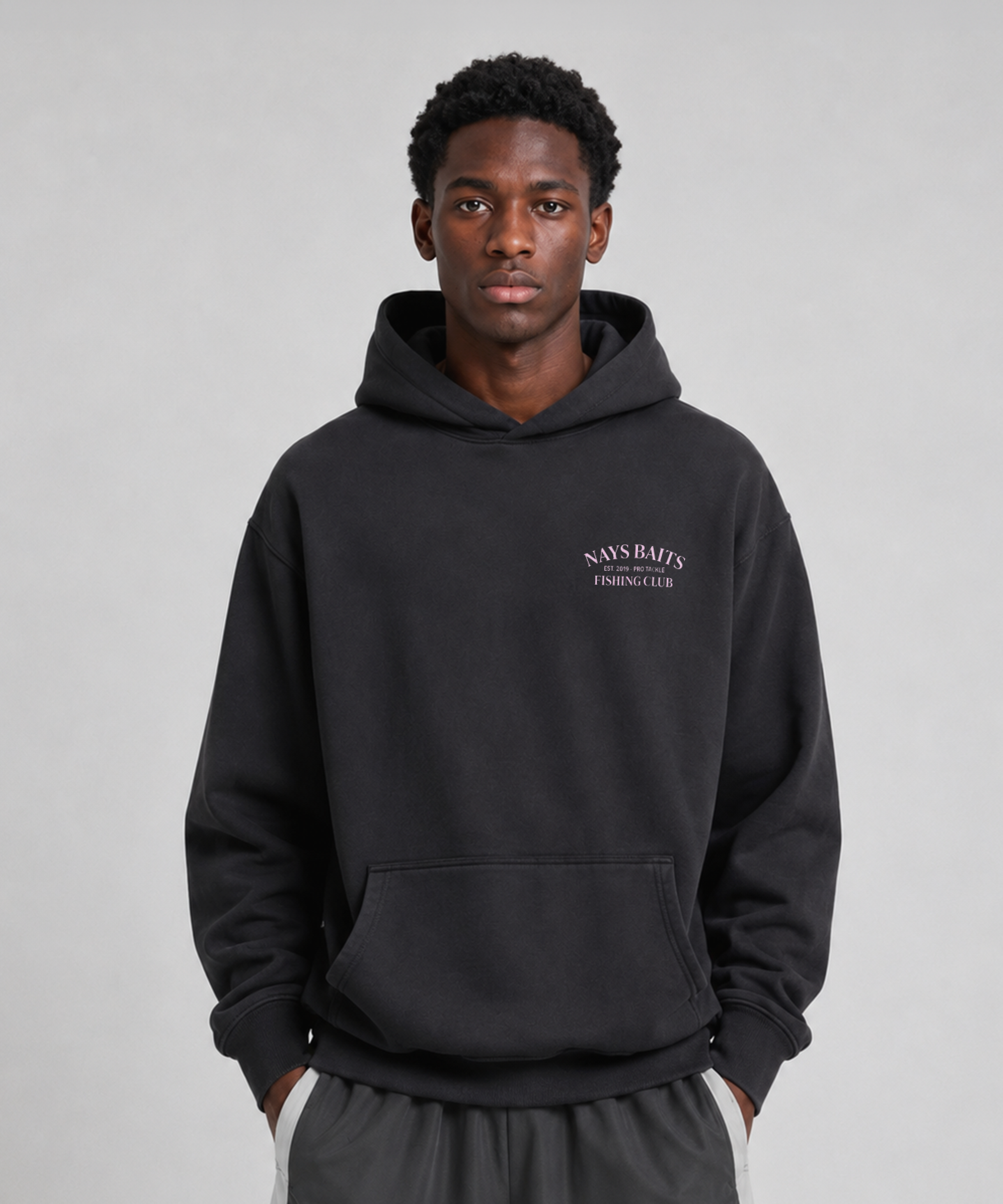Model trägt Schwarzer Nays Baits Fishing Club Hoodie mit Kapuze, Kängurutasche und dezentem Brustprint.