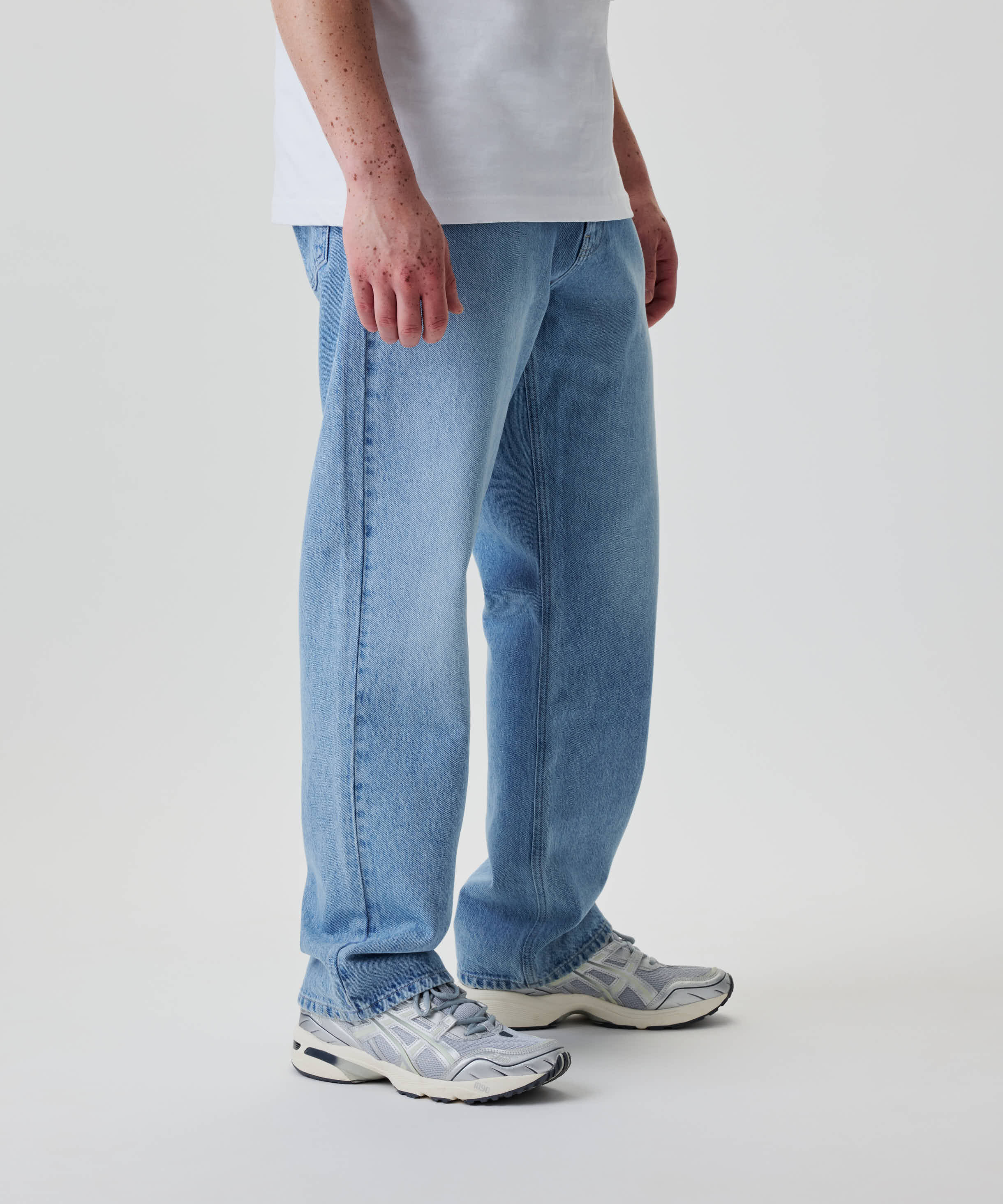 Nays Straight Fit Jeans in hellem Wash, aus 100% Baumwolle, mit geradem Schnitt und klassischem 5-Pocket-Design, getragen mit grauen Sneakers.