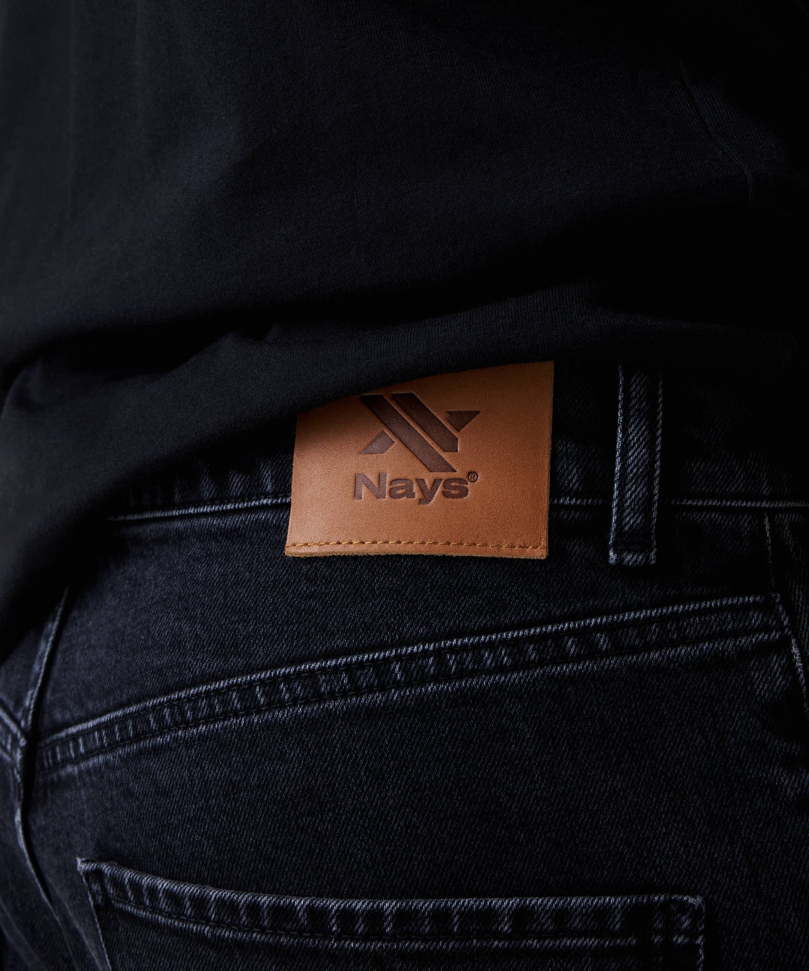 Nahaufnahme der Nays Regular Fit Jeans mit braunem Logo-Patch am Bund, zeigt das klassische 5-Pocket-Design und hochwertige Verarbeitung aus elastischem Denim.