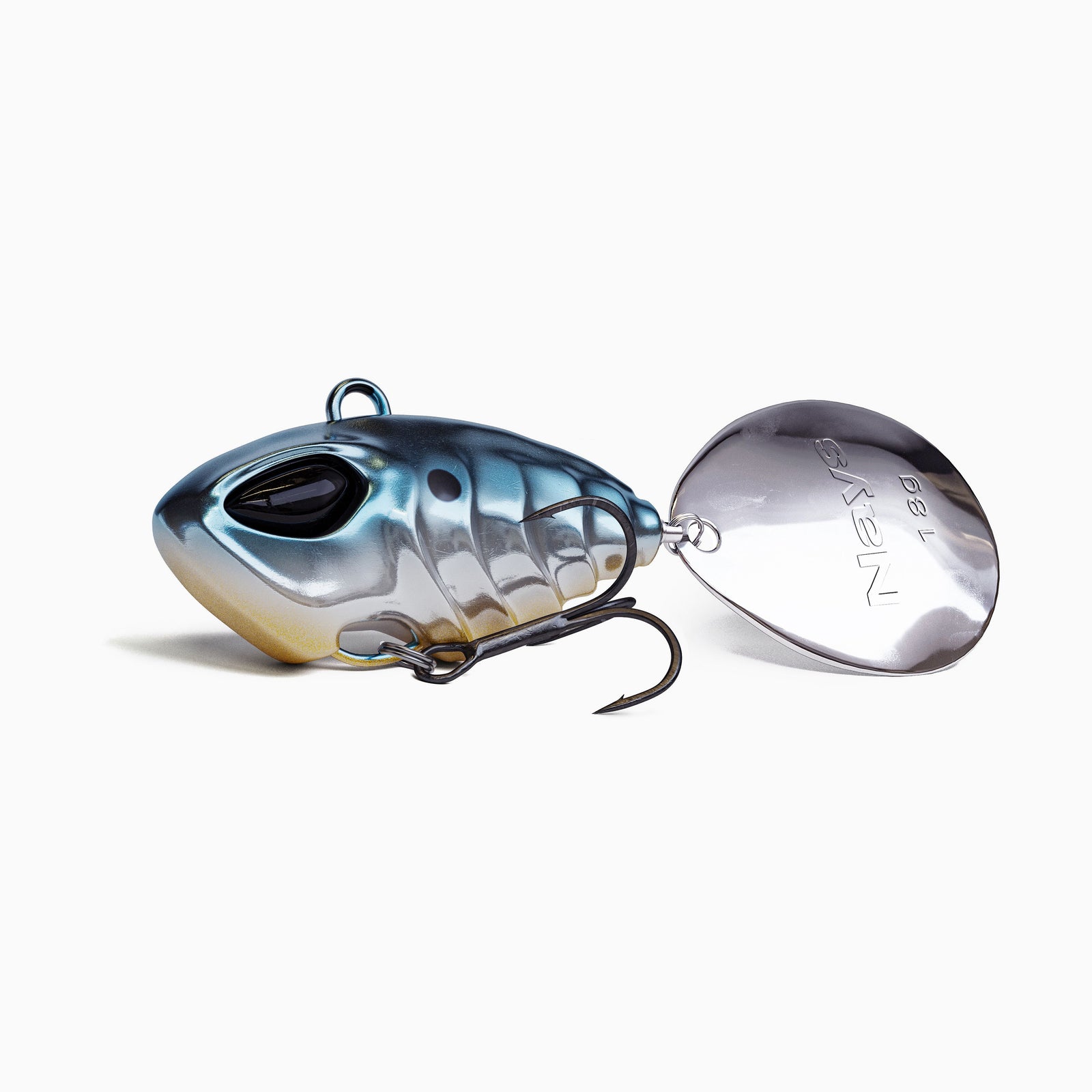 Das Bild zeigt einen Jig Spinner. Der tropfen-förmige Körper ist farblich abgestuft von blau über Silber mit goldenen Akzenten. Realistisches Augen-Design, ausgestattet mit einem BKK Drillingshaken und einem silbernen Spinner Blatt. 