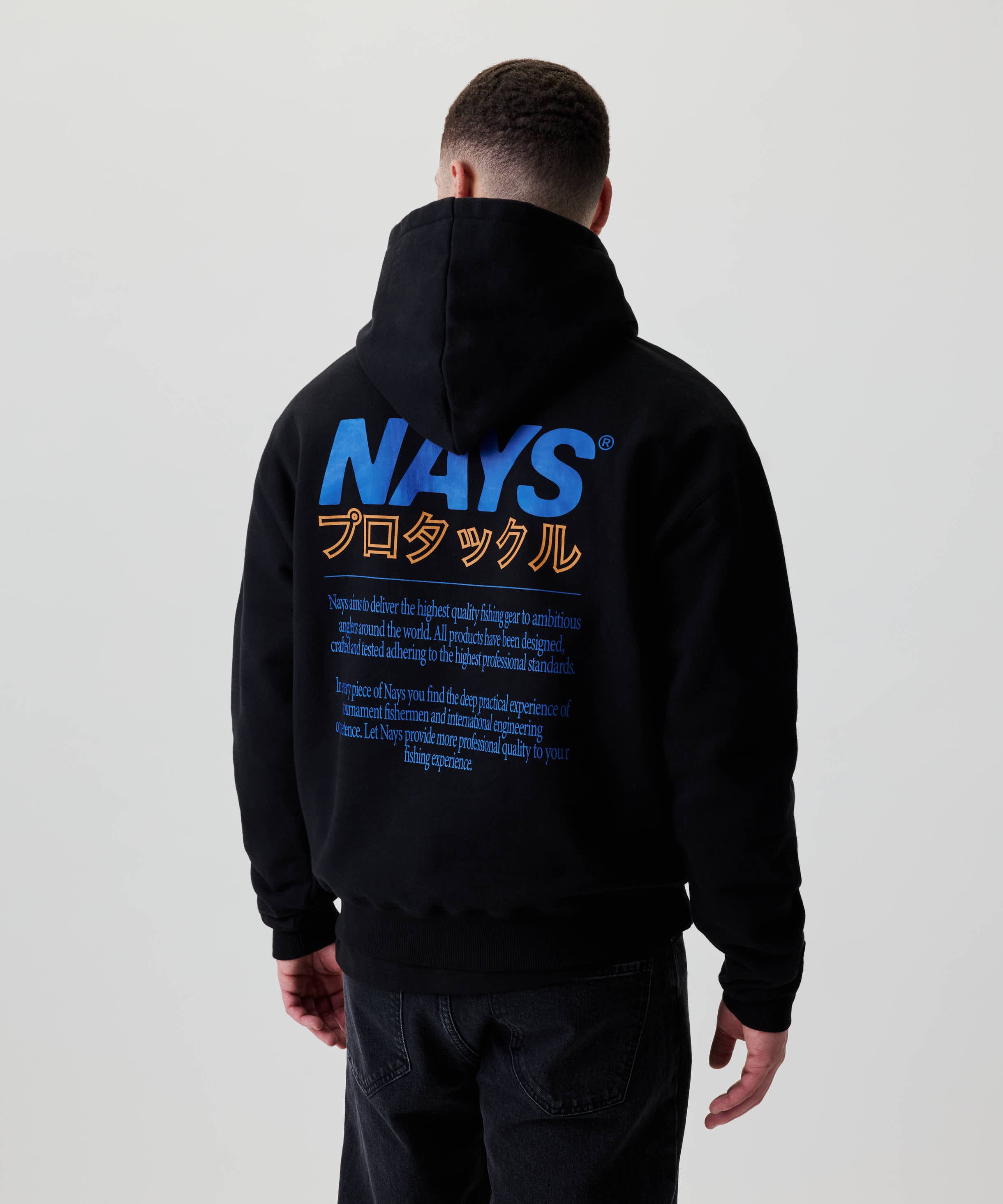 Rückansicht des Nays Pro Tackle International Hoodie mit großem Rückenprint „NAYS“ in Katakana, getragen von einer Person.