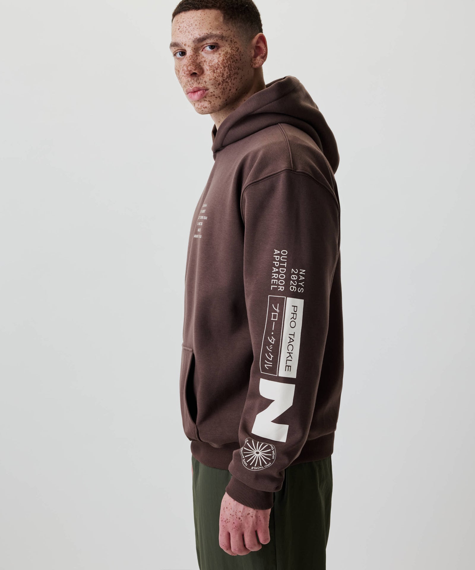 Junger Mann im Profil trägt den Nays Quote Hoodie mit weißen Grafiken auf dem Ärmel, aus Baumwoll-Polyester-Mix, ideal für Alltag und kühle Tage.