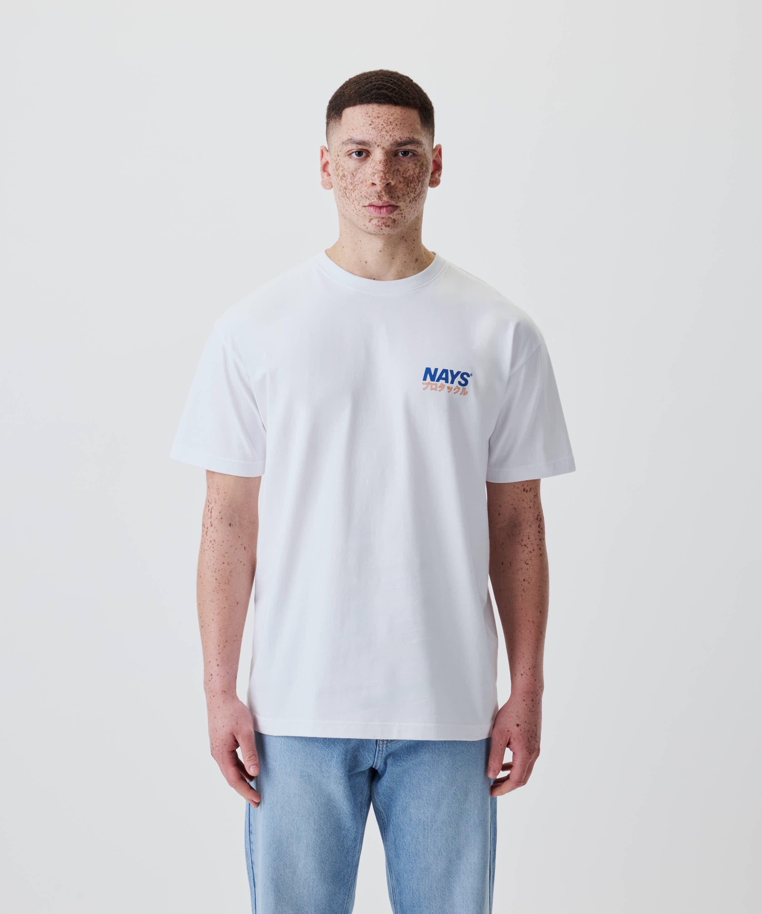 Junger Mann trägt das Nays Pro Tackle International Tee mit kleinem Logo vorne, aus 100% Baumwolle, lässiger Schnitt, ideal für Alltag und Freizeit.