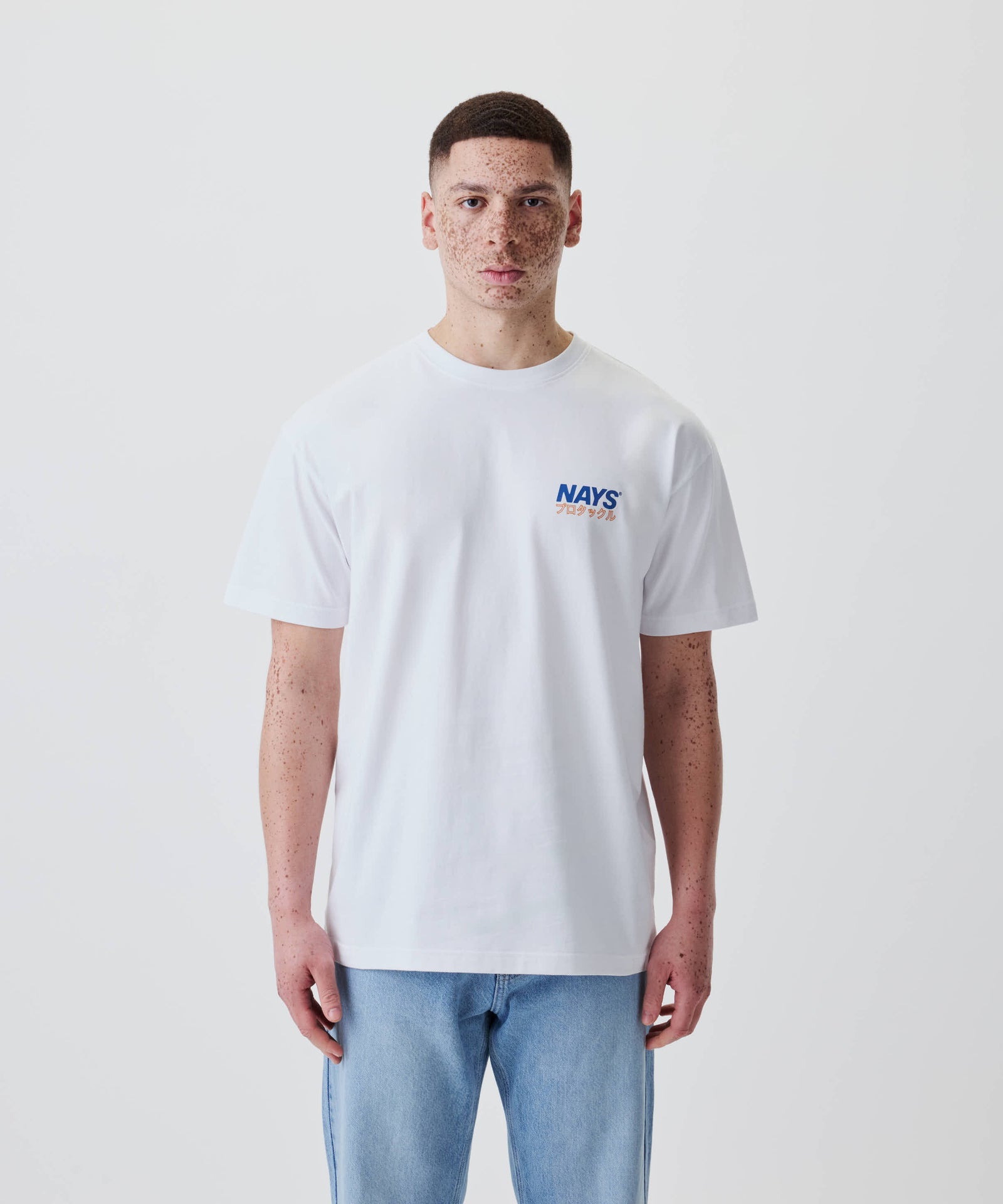 Junger Mann trägt das Nays Pro Tackle International Tee mit kleinem Logo vorne, aus 100% Baumwolle, lässiger Schnitt, ideal für Alltag und Freizeit.