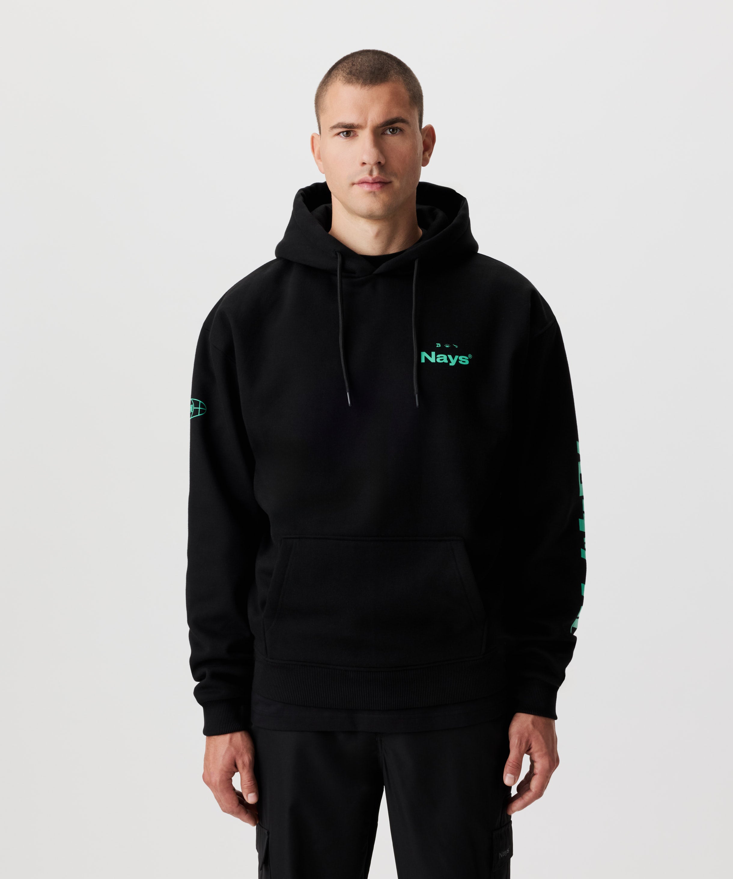 Vorderansicht Mann im schwarzen Kapuzen-Sweatshirt mit grünen Prints auf der Brust und beiden Ärmeln.