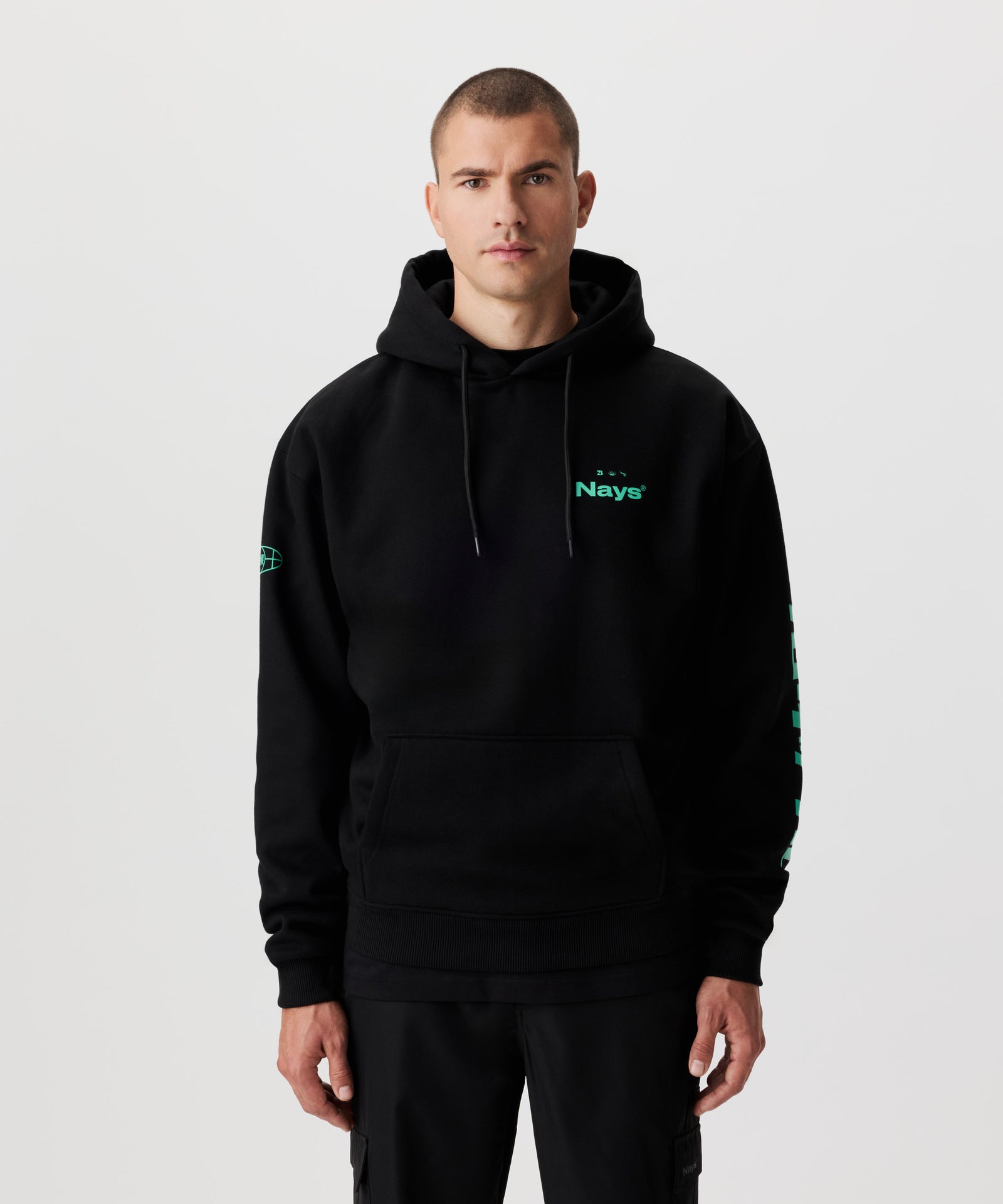 Vorderansicht Mann im schwarzen Kapuzen-Sweatshirt mit grünen Prints auf der Brust und beiden Ärmeln.