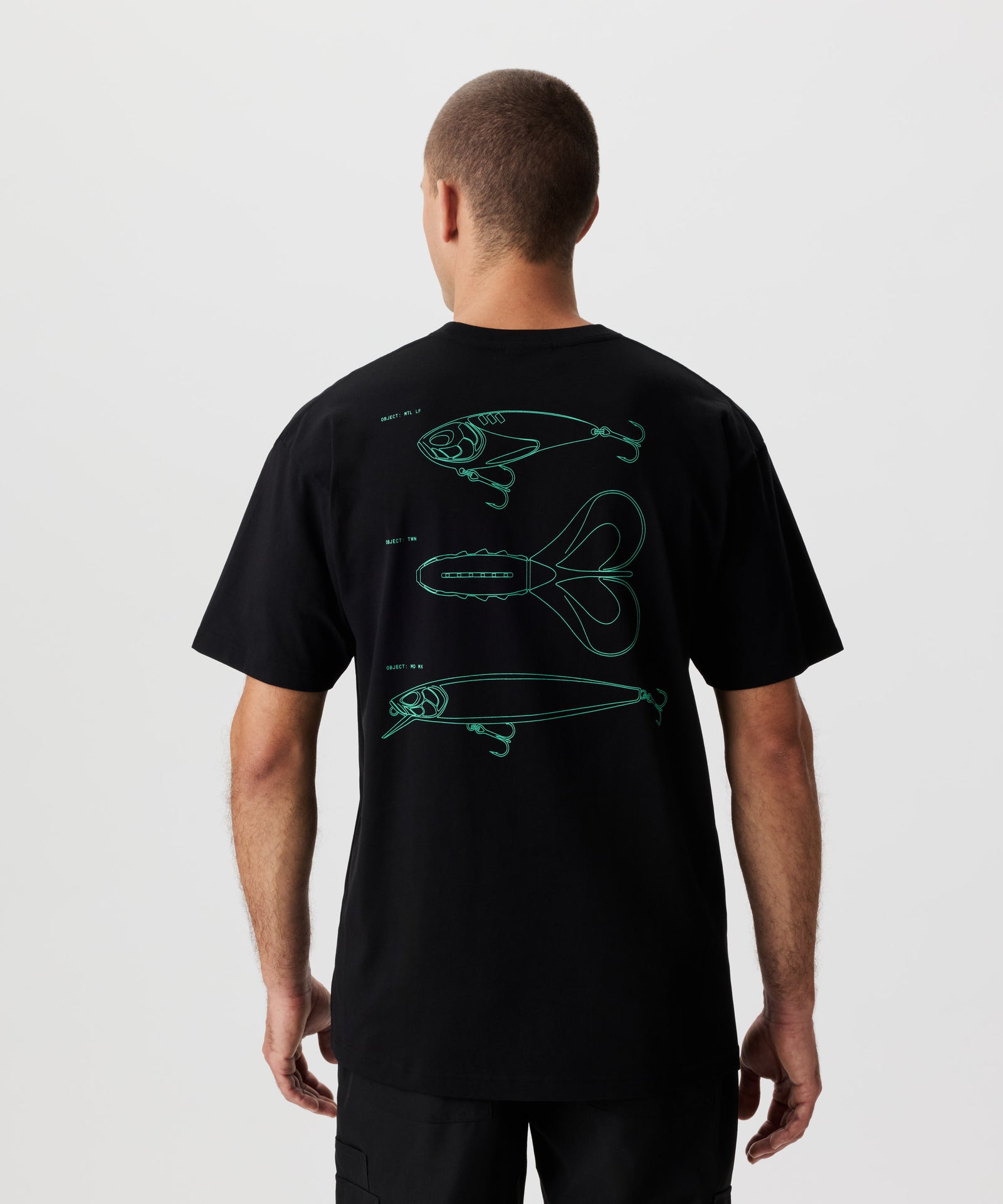 Rückansicht Mann im schwarzen T-Shirt und grünem Rücken-Print. Der Print zeige drei bekannte Köder-Silhouetten.