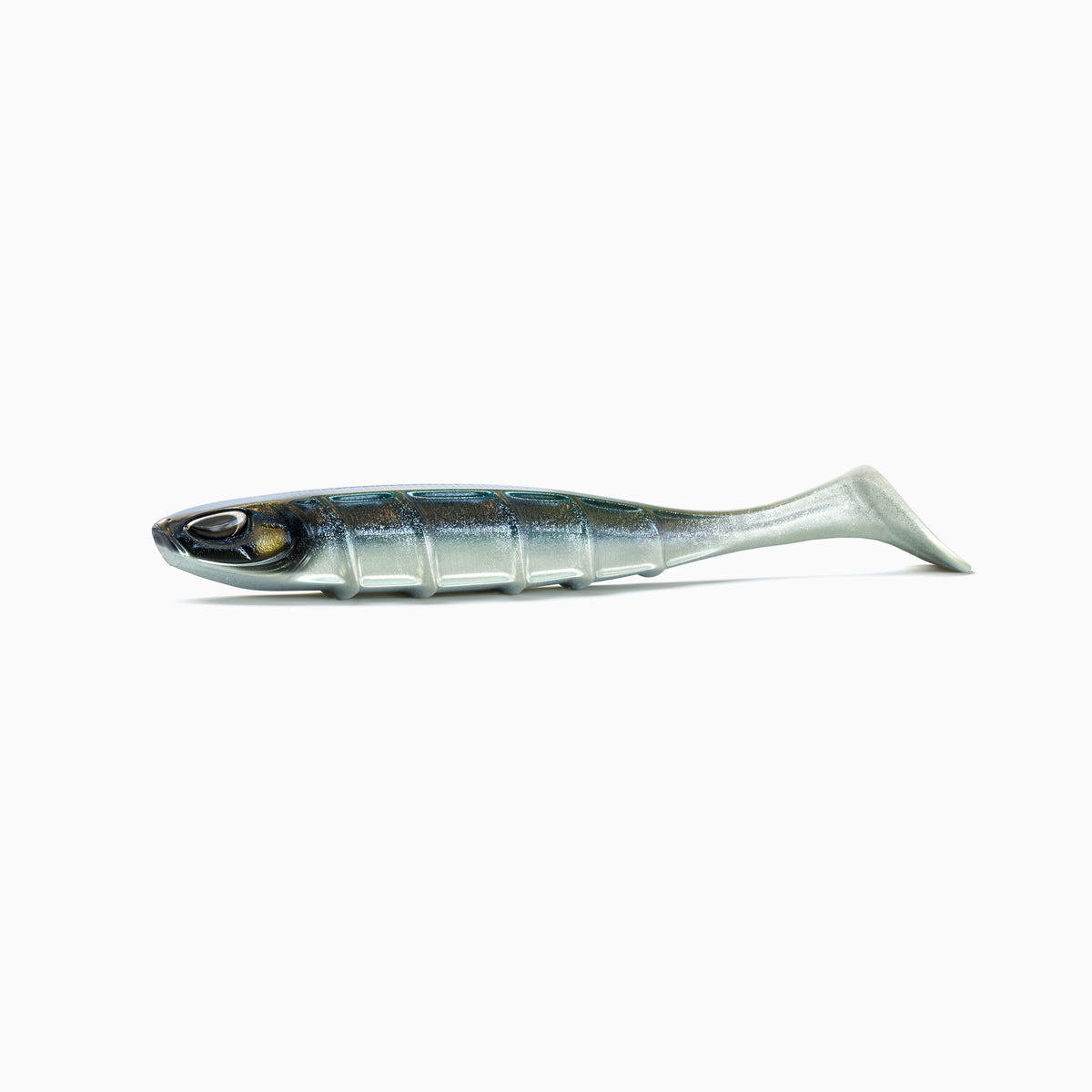 Ein Angelköder in Form eines Fisches liegt waagerecht auf weißem Hintergrund. Der silberne Körper hat einen dunklen, blau-grün schimmernden Rücken und zeigt seitlich feine Schuppenmuster mit einer sichtbaren Rippenstruktur. Die Augen sind realistisch gestaltet, mit schwarzen Pupillen und goldenen Akzenten. Am hinteren Ende befindet sich ein voluminöser Schaufelschwanz.