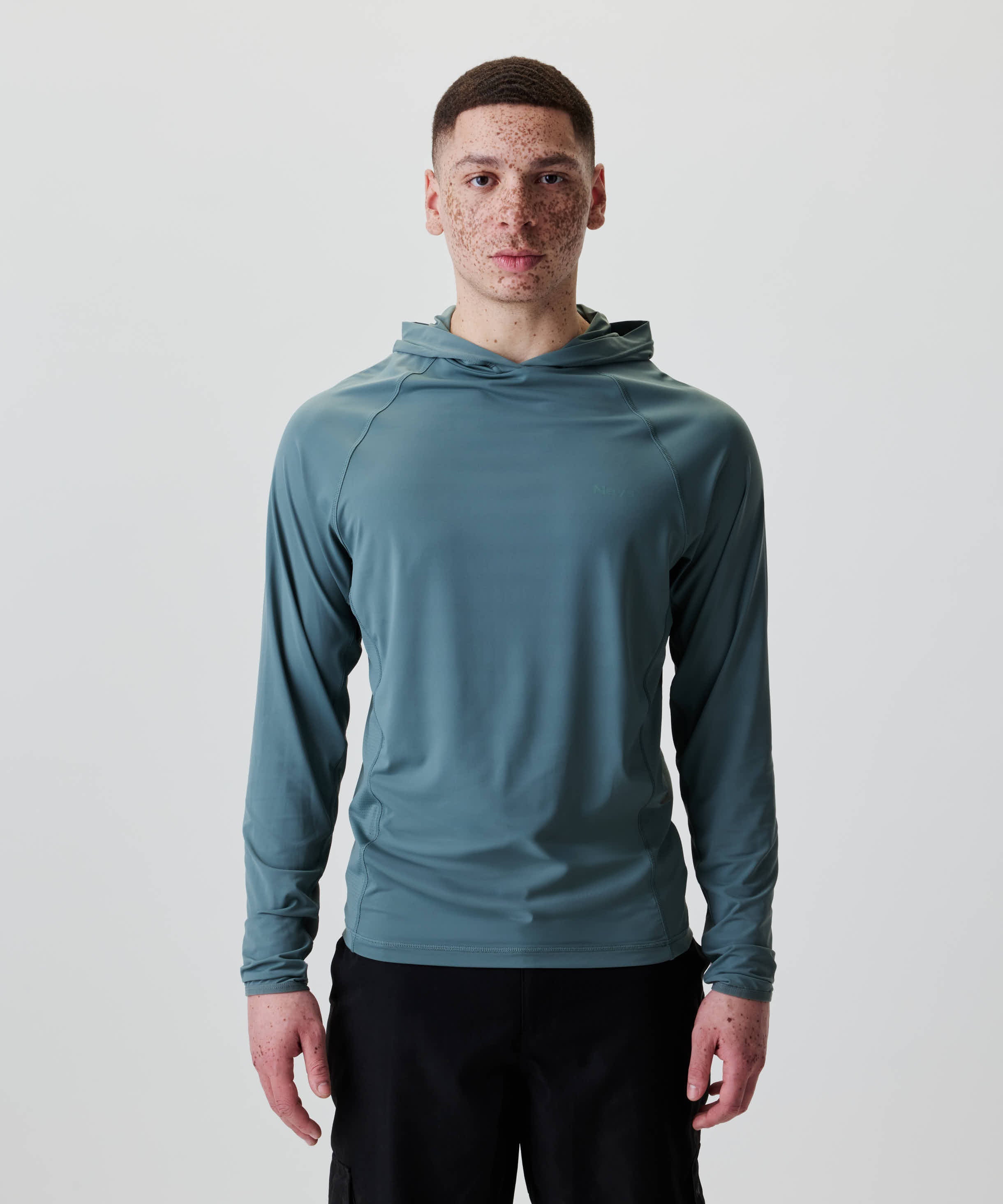 Junger Mann trägt Nays UV 50+ Hooded Longsleeve mit Raglanärmeln und Kapuze, ideal für Sonnenschutz, abgebildet in einem Katalogfoto.