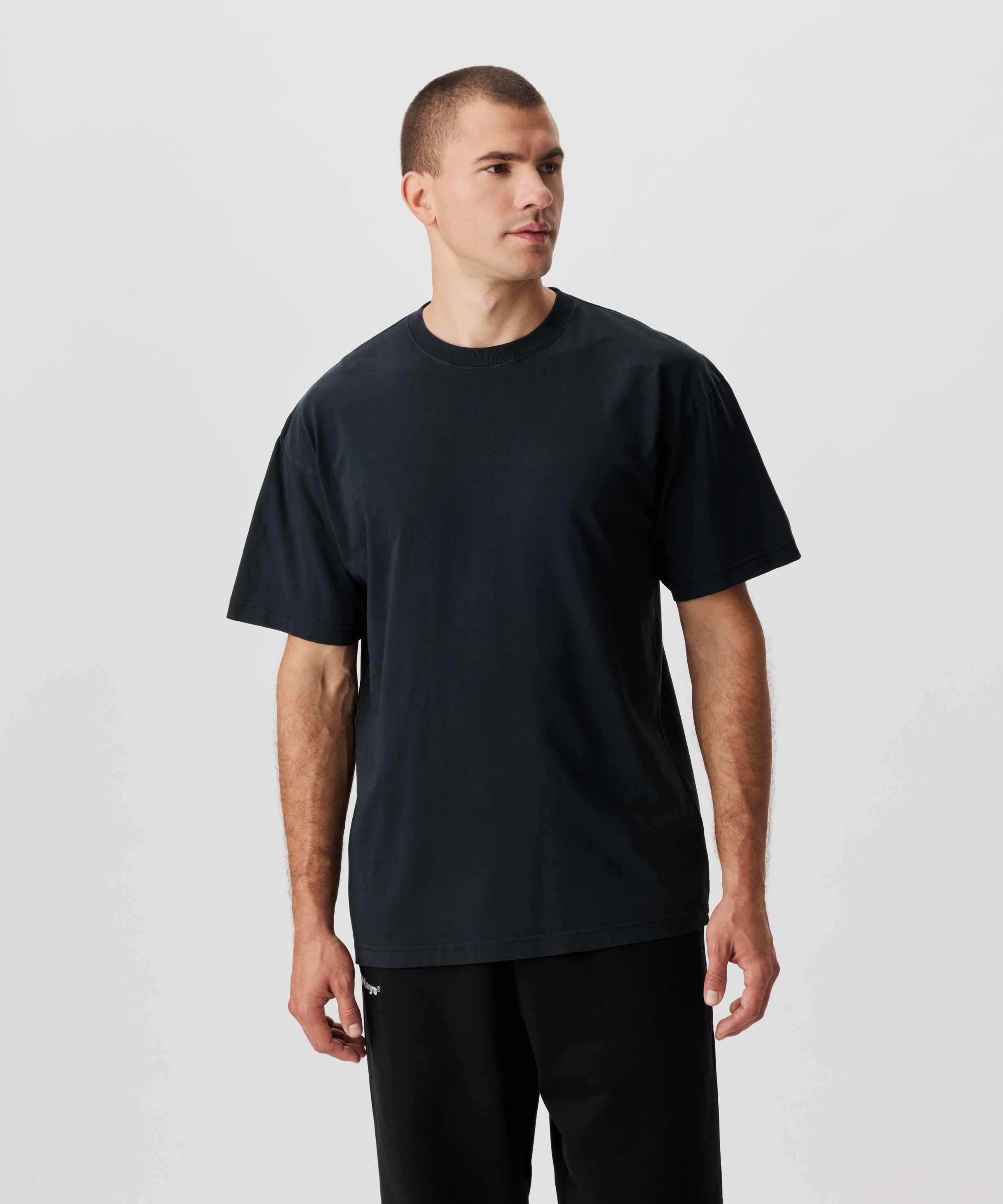 Frontansicht Mann mit anthrazitfarbenem T-Shirt und schwarzer Hose.