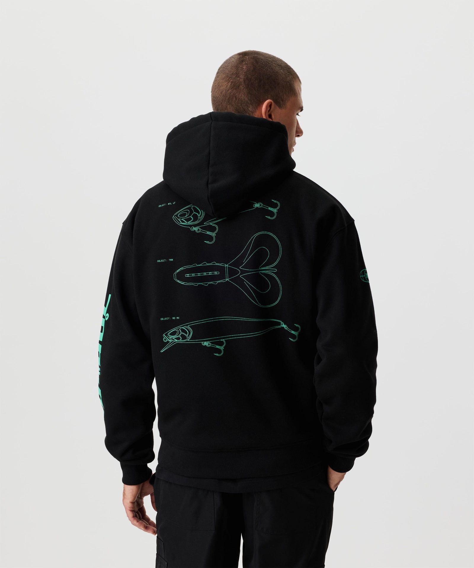 Rückansicht Mann im schwarzen Pullover mit grünem Ruecken- und Aermel-Druck.