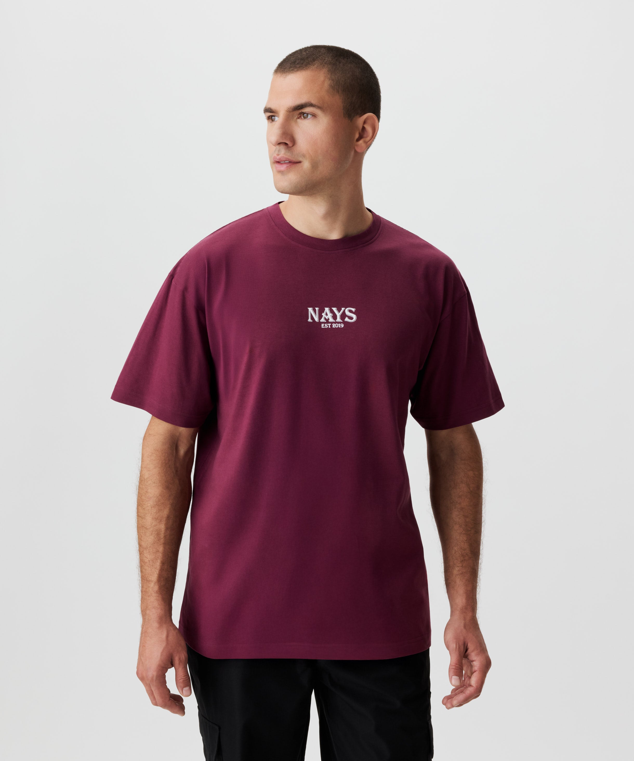 Frontale Ansicht Mann im weinroten T-Shirt. Das T-Shirt hat einen mittig gesetztes Nays-Logo in weiß.