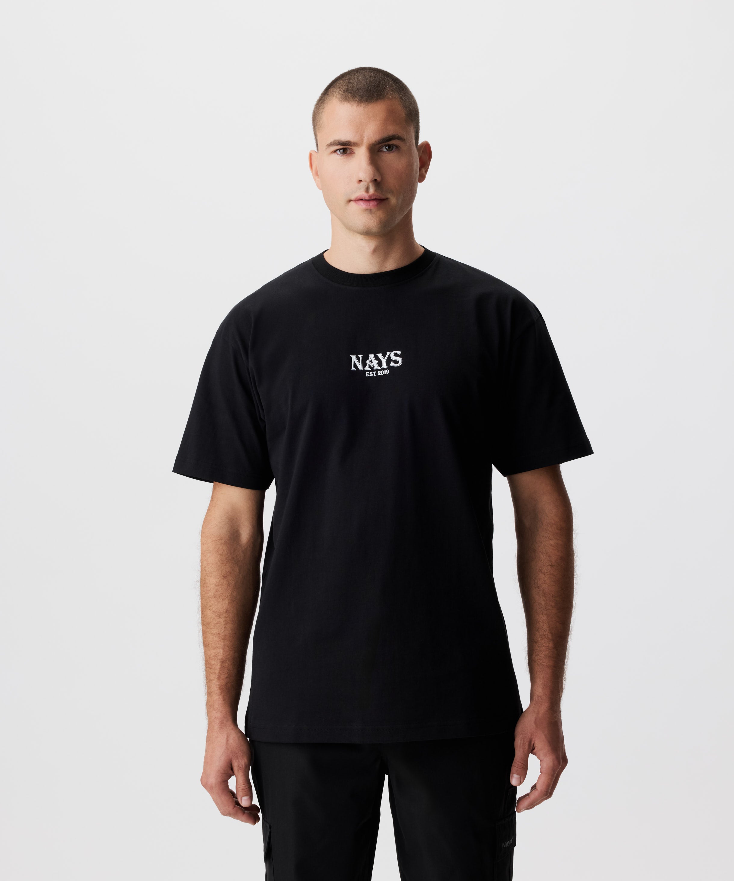 Frontansicht Mann im schwarzen T-Shirt. Das T-Shirt hat einen mittig gesetztes Nays-Logo in weiß.