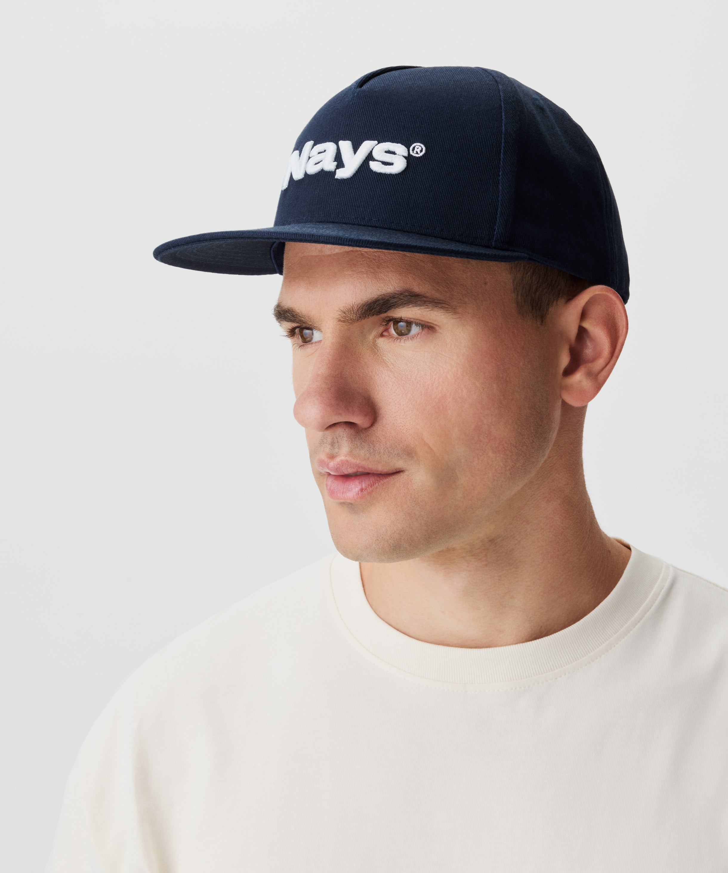 Seitenansicht Mann mit blauer Cap. Ein weißes Nays-Logo ziert die Cap.