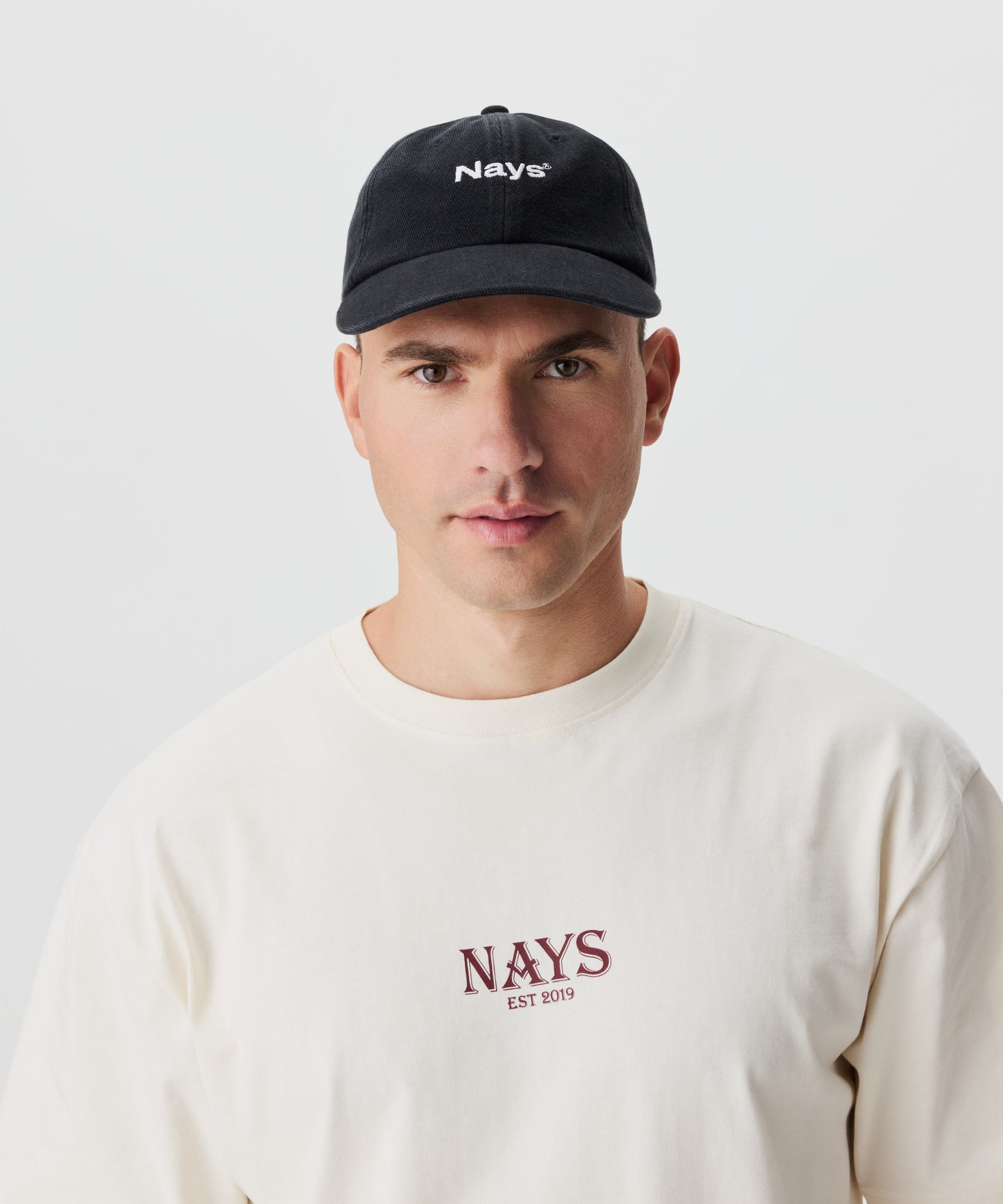Frontale Ansicht Mann mit dunkelgrauer Cap und Nays-Logo-Schriftzug vorne.