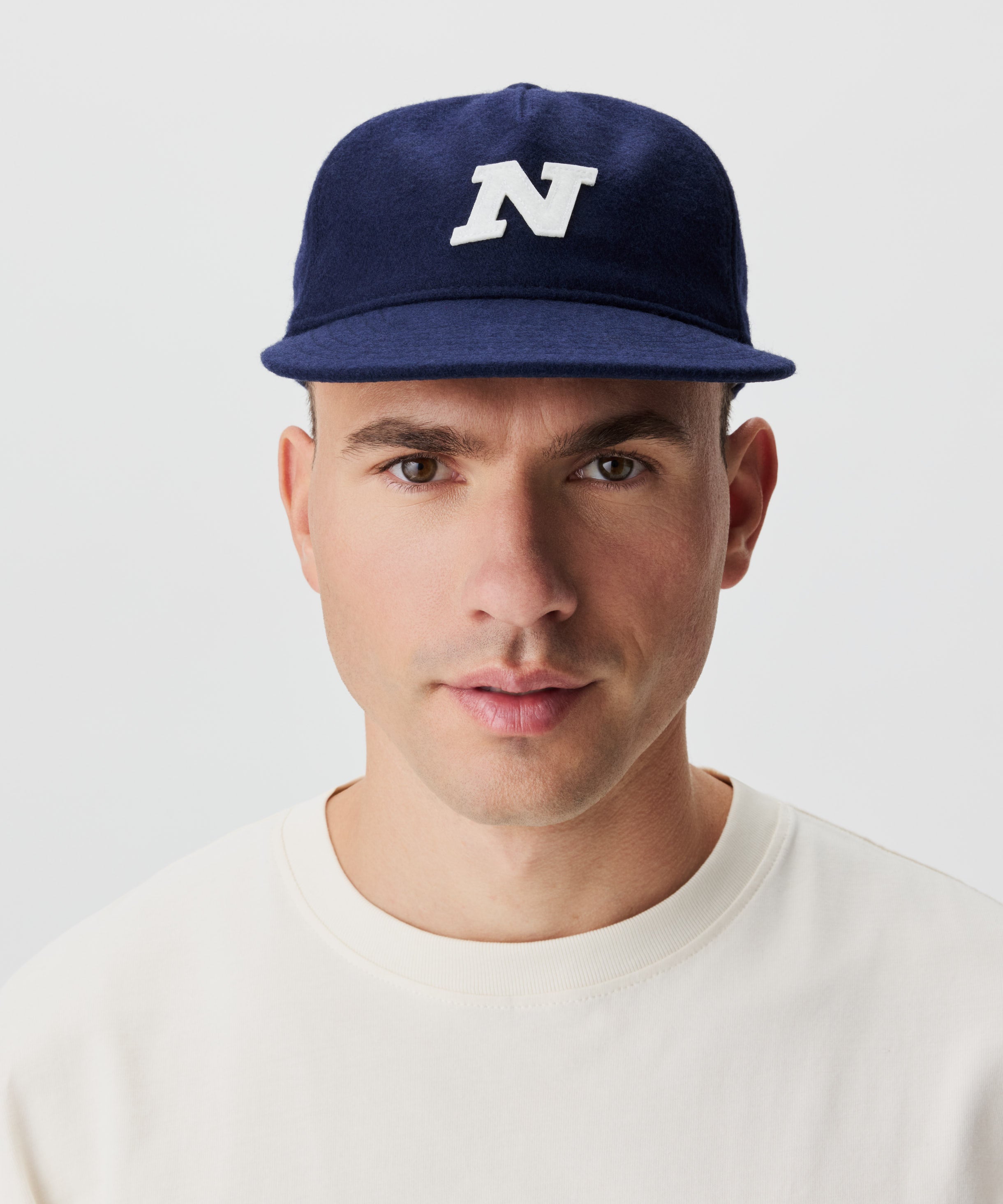 Frontale Ansicht Mann mit blauer Cap und großem N-Logo vorne.