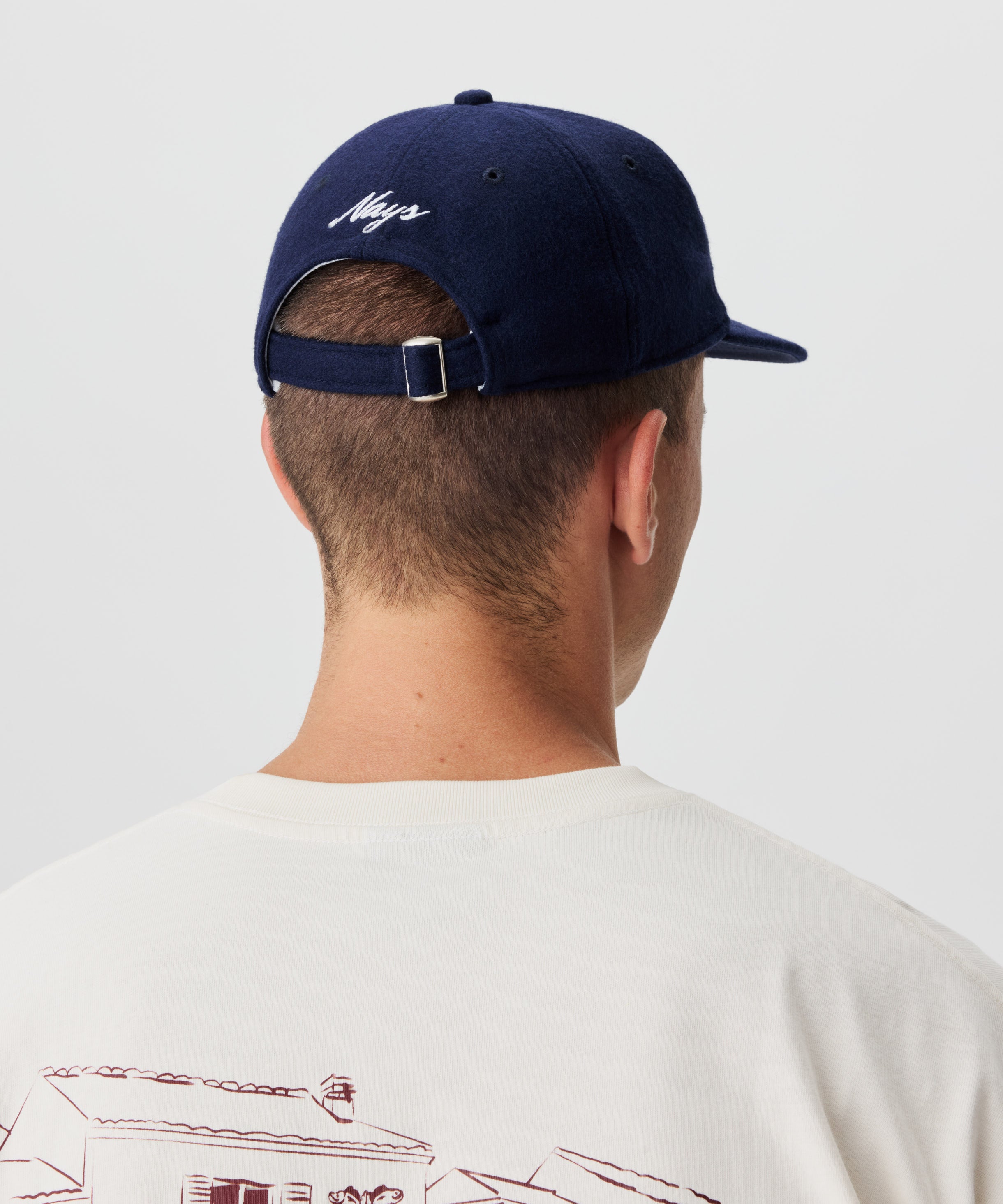 Rückansicht Mann mit blauer Cap und dezentem Nays-Logo am Hinterkopf.
