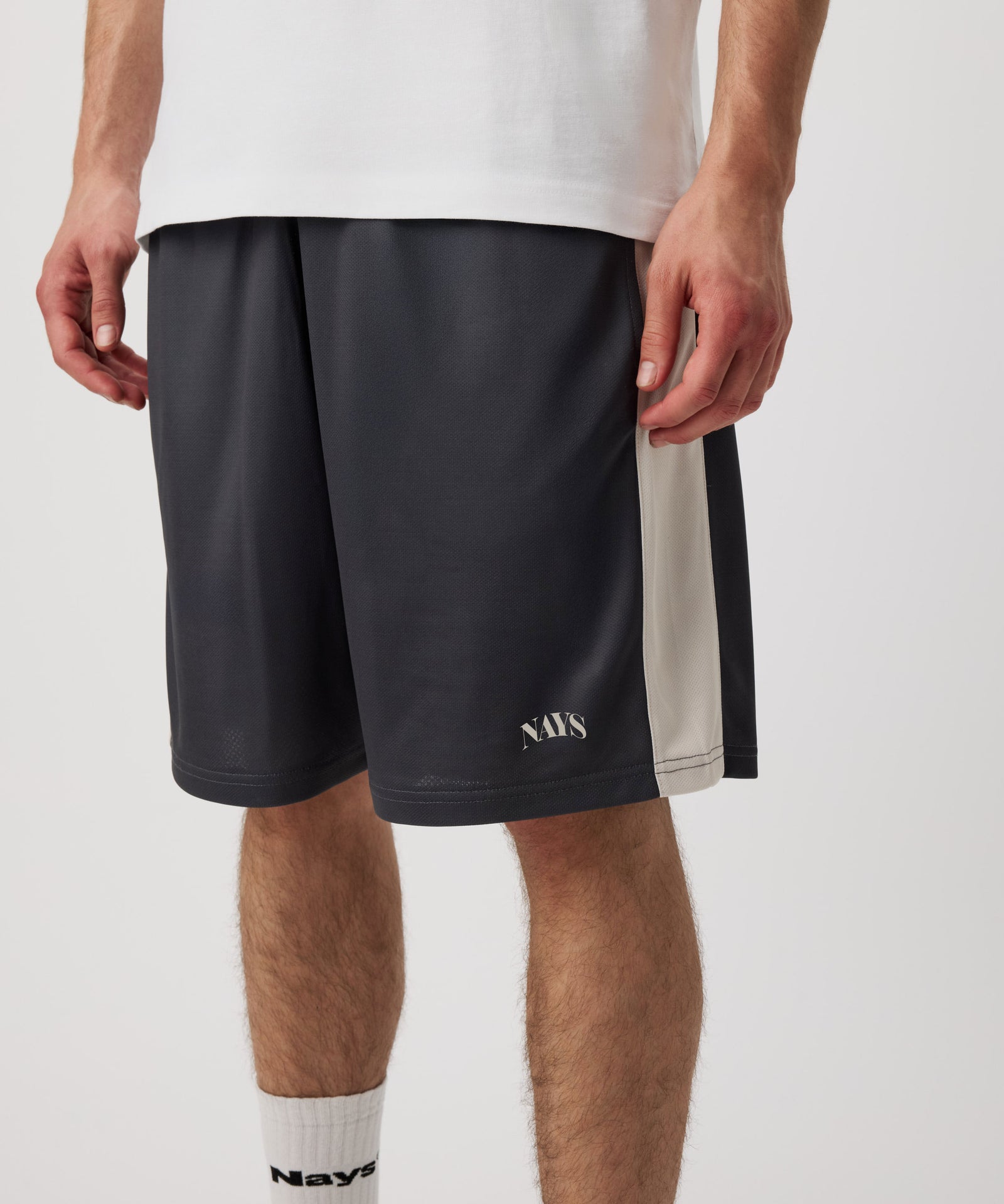 Das Model trägt eine blau-graue-kurze Hose. Auf diesem Bild gut zu erkennen ist ein dezente, weißes Nays Logo auf dem linken Bein.